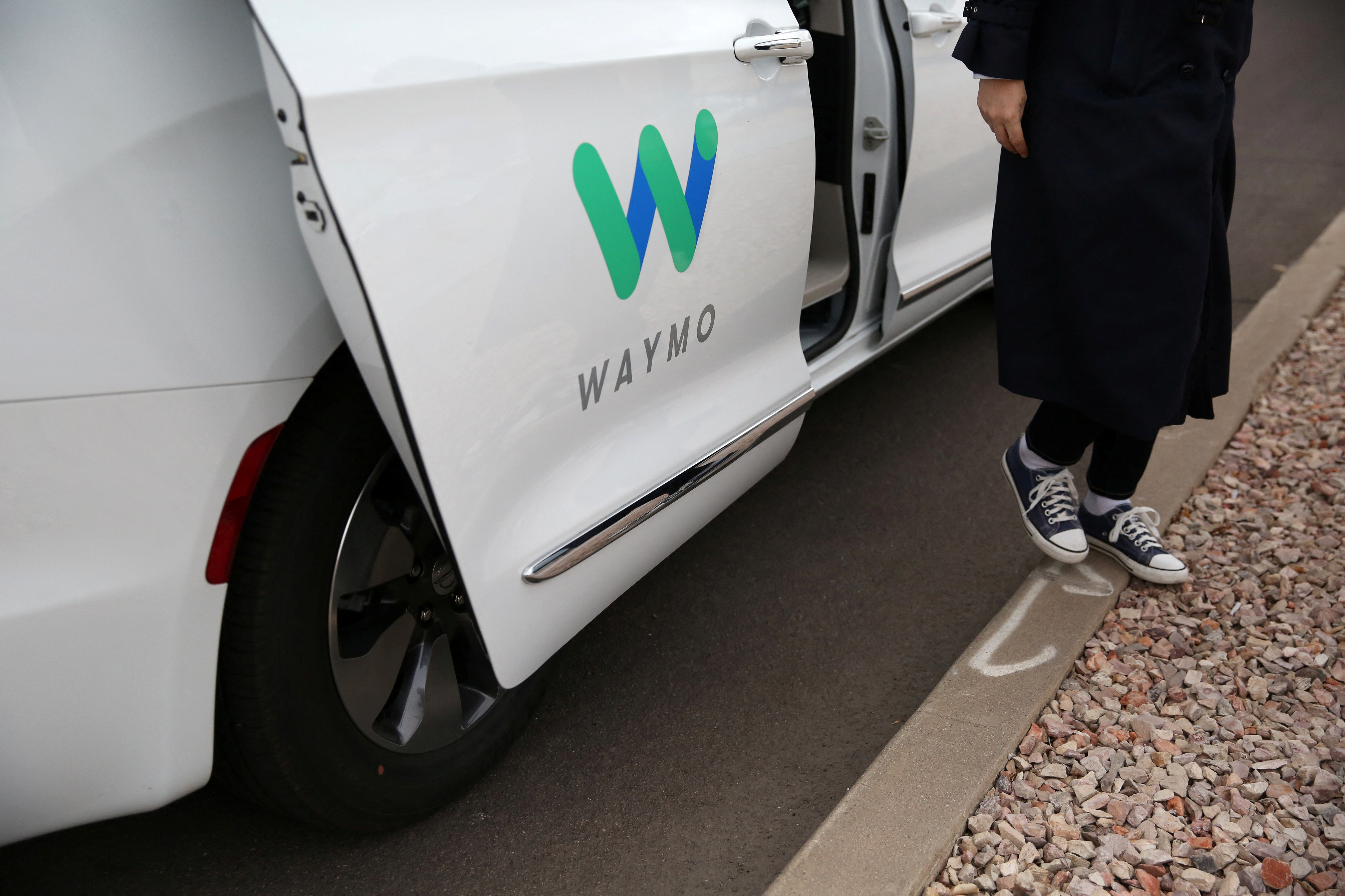Reuters reporter Alexandria Sage steps out of a Waymo self-driving vehicle during a demonstration in Chandler, Arizona