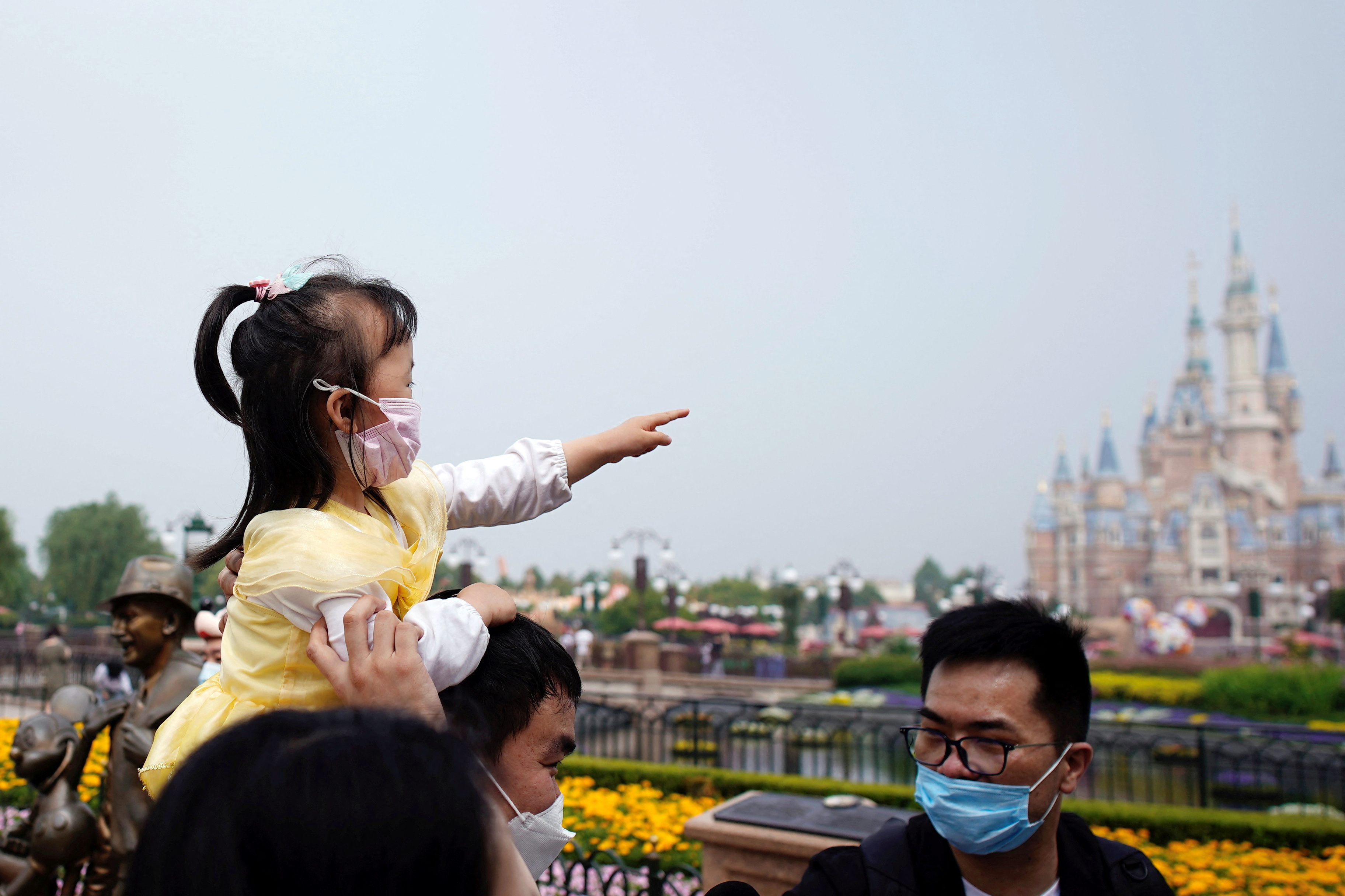 Visitors wearing face masks are seen at the Shanghai Disneyland