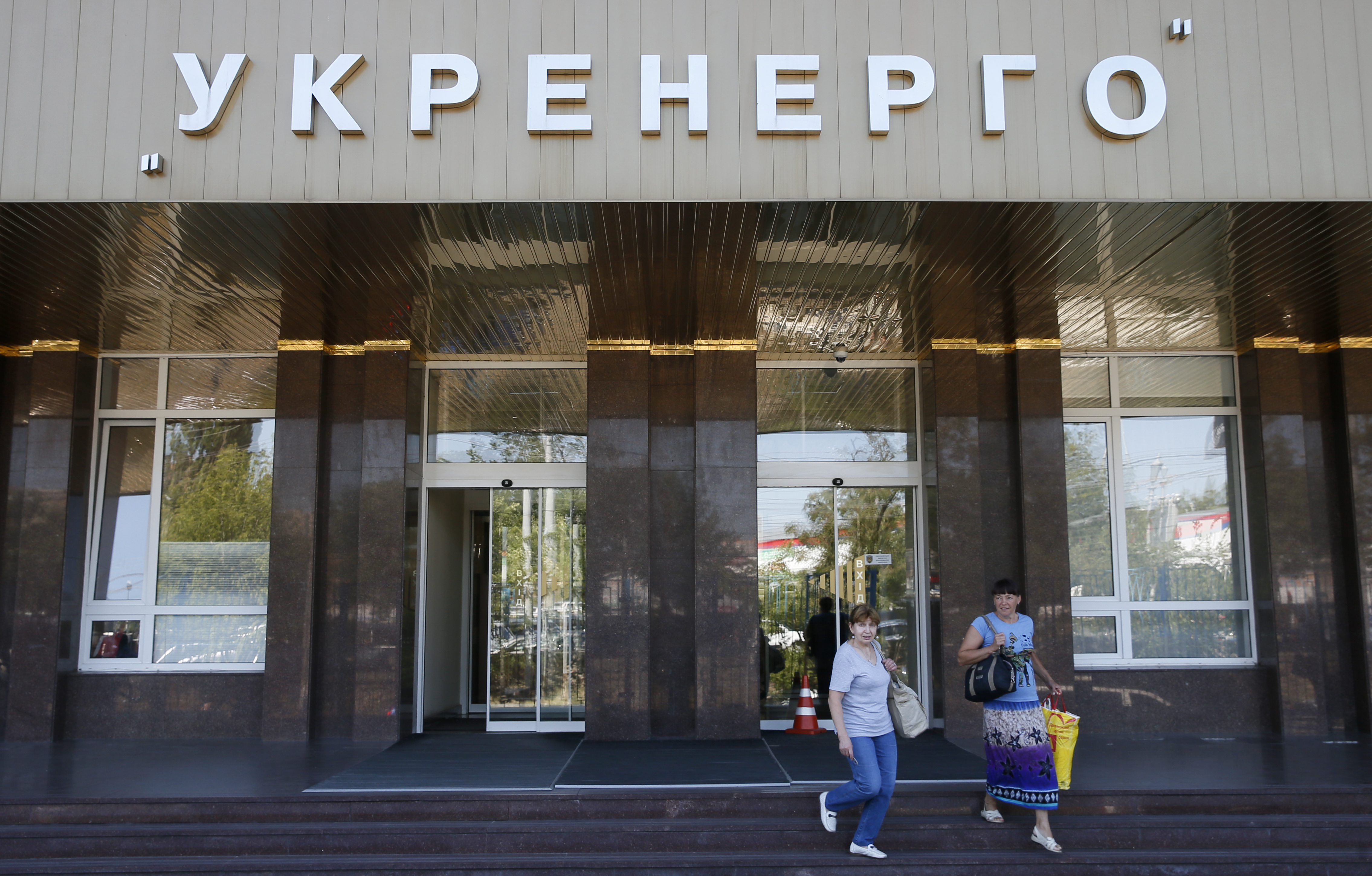 Women walk outside the headquarters of Ukrainian state power distributor Ukrenergo in Kiev