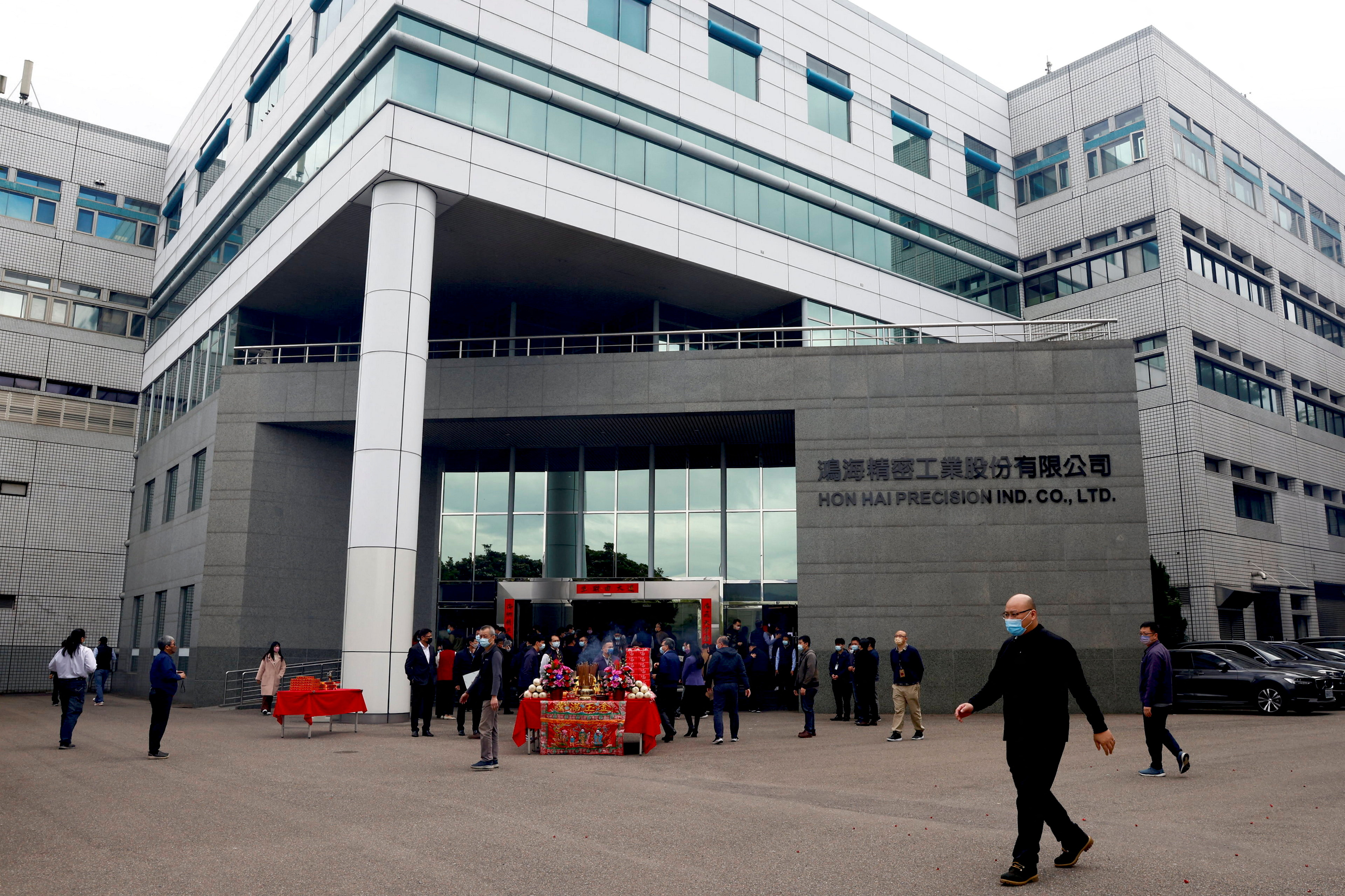 A man walks past Foxconn building after a new year prayer in New Taipei City,