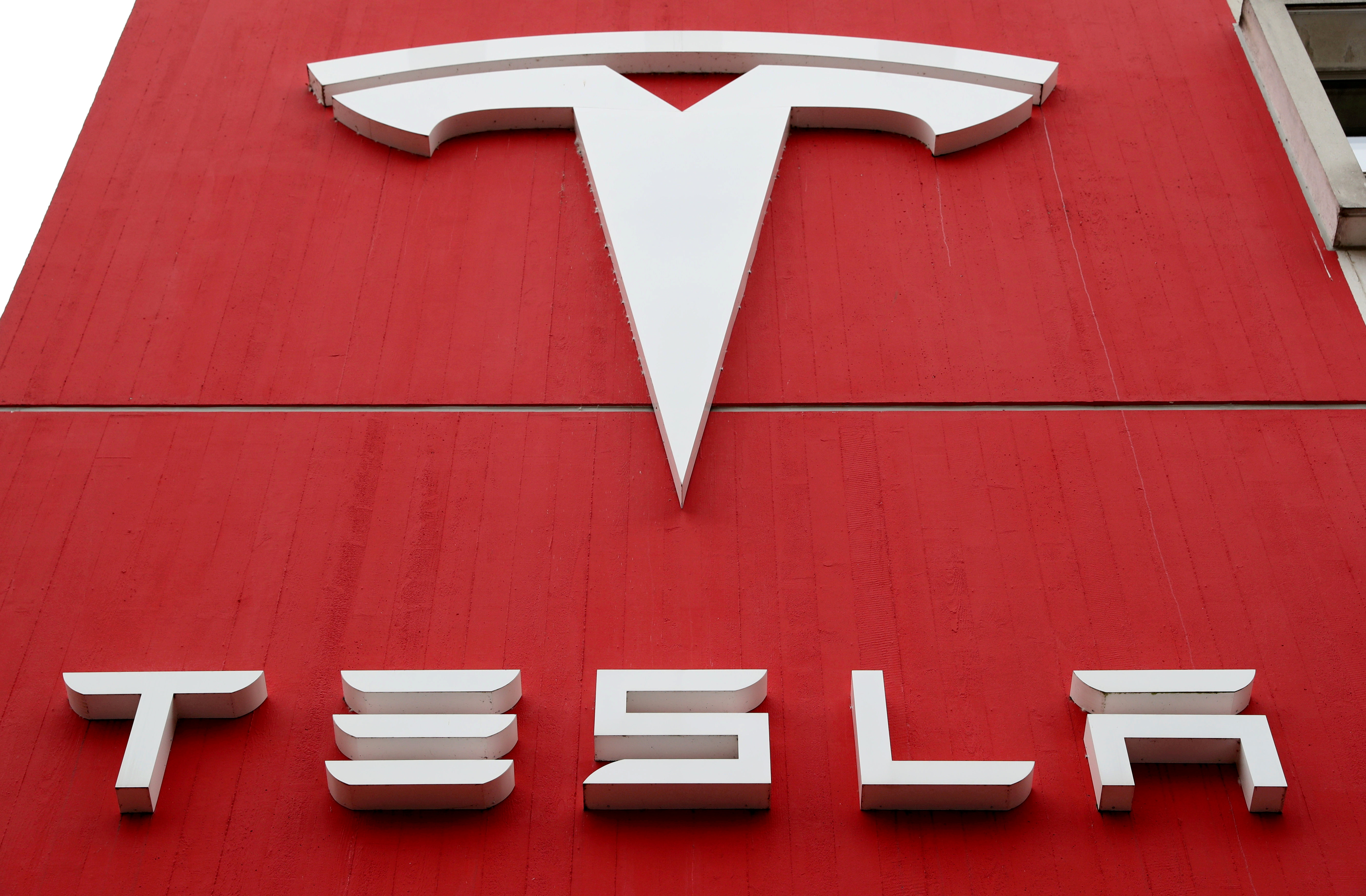 The logo of car manufacturer Tesla is seen at a branch office in Bern, Switzerland, October 28, 2020. REUTERS/Arnd Wiegmann/File Photo