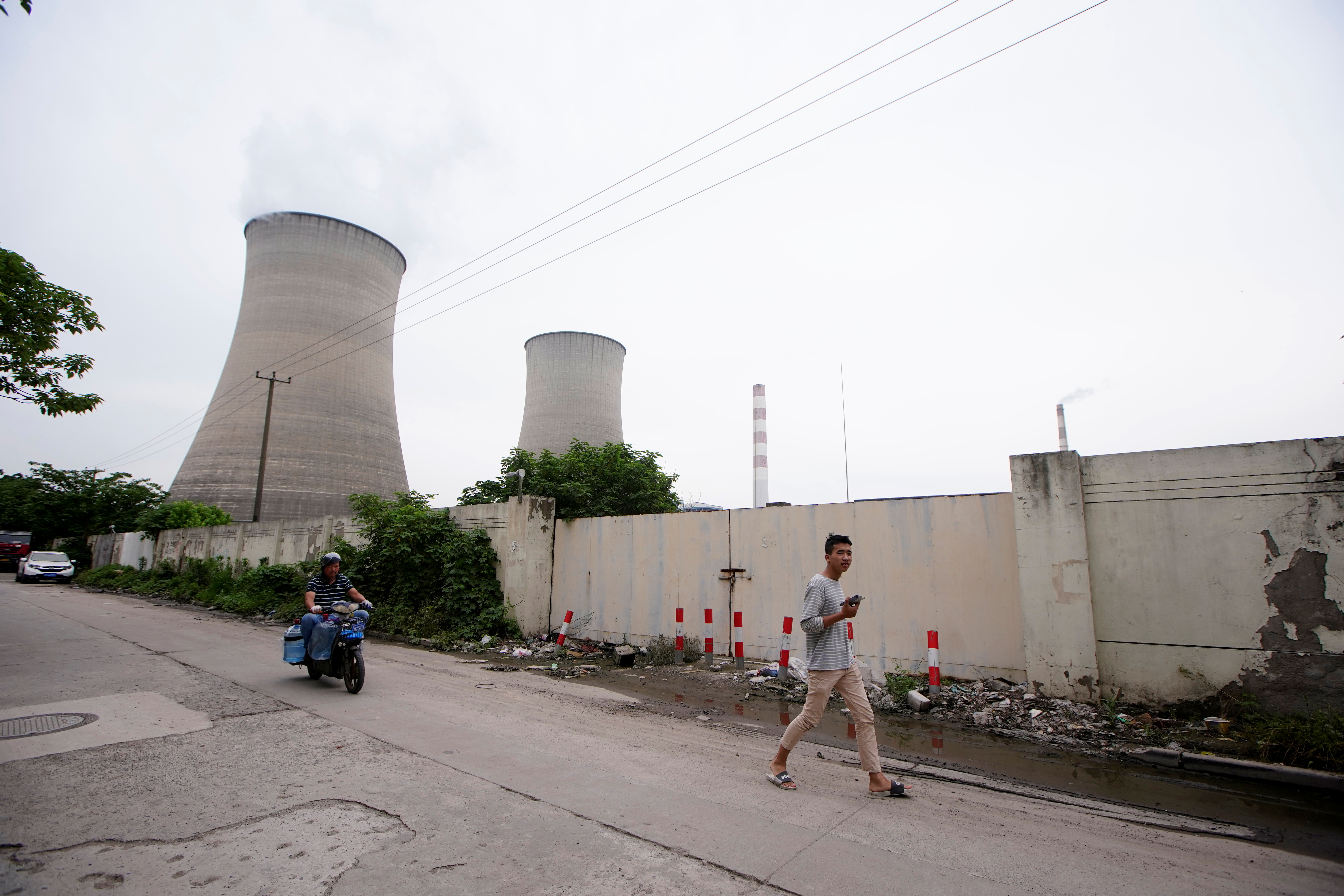 A man walks past a coal-fired power plant in Shanghai