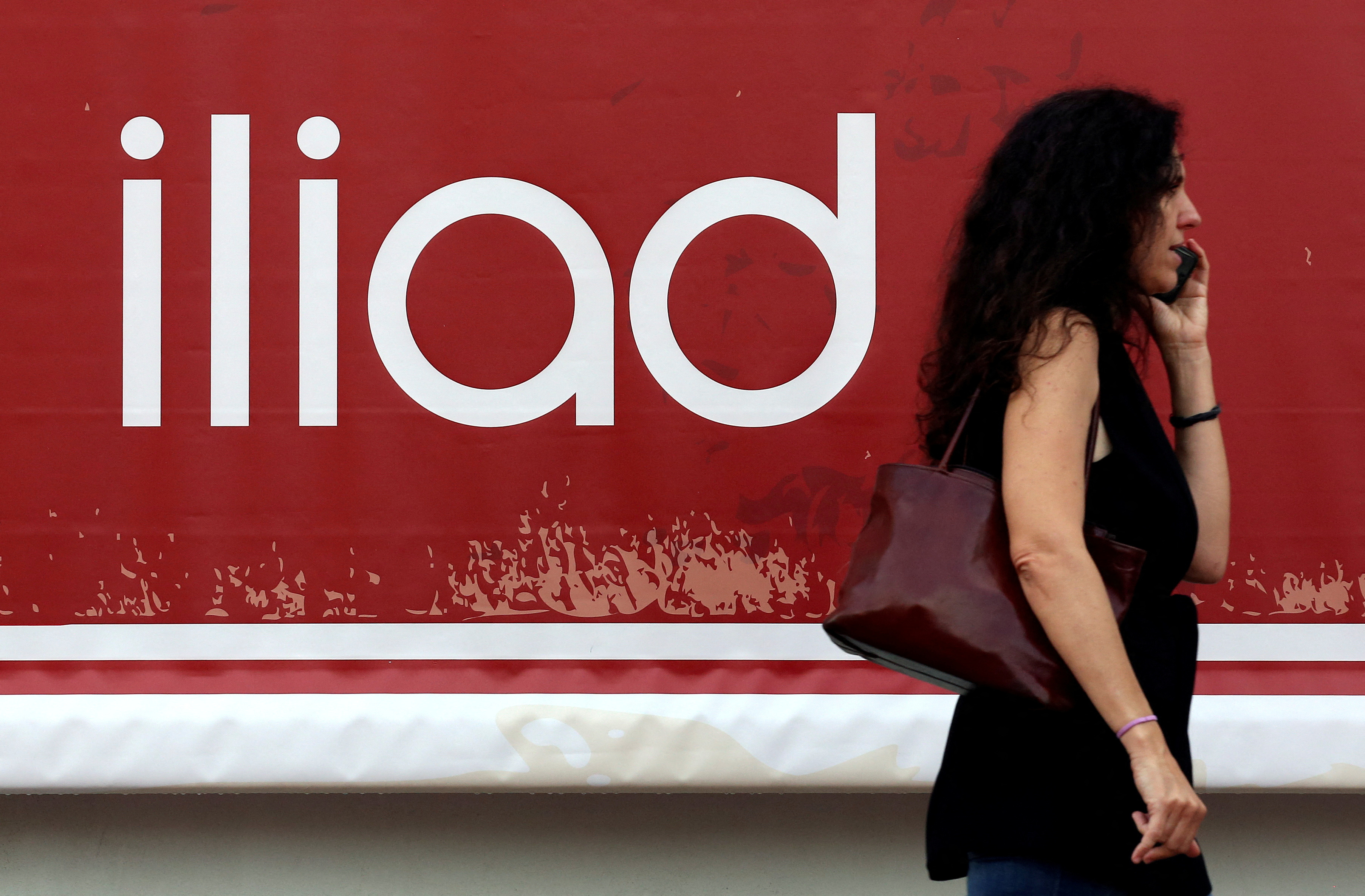 A guest speaks on a mobile phone as she arrives for the French telecoms operator Iliad's media conference in Milan