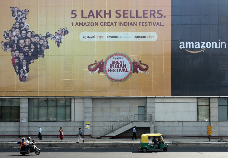 People move past a hoarding of Amazon India outside a metro rail station in New Delhi,