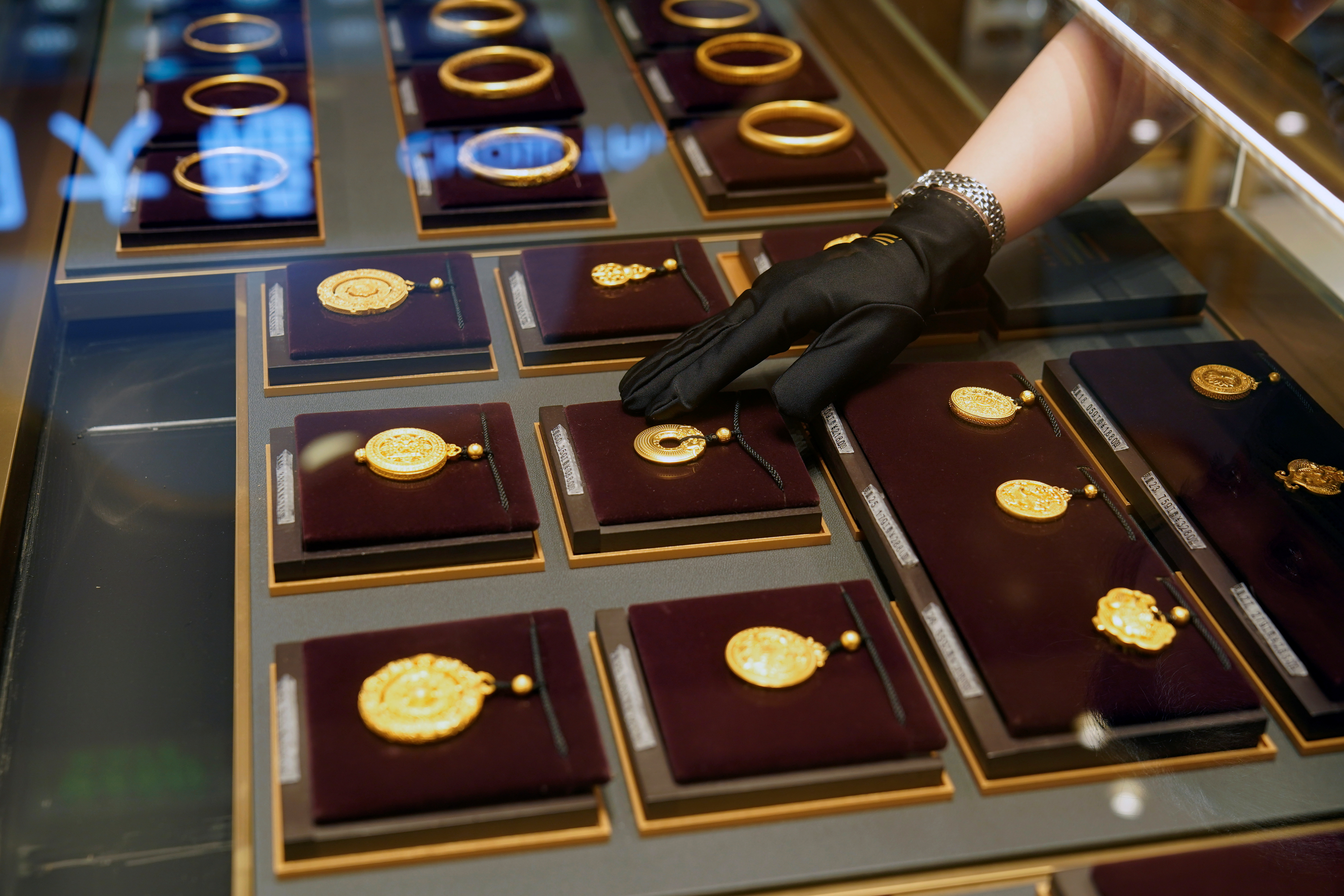 A salesperson poses with Heritage Gold jewellery at jeweller Chow Tai Fook’s retail store in Shanghai