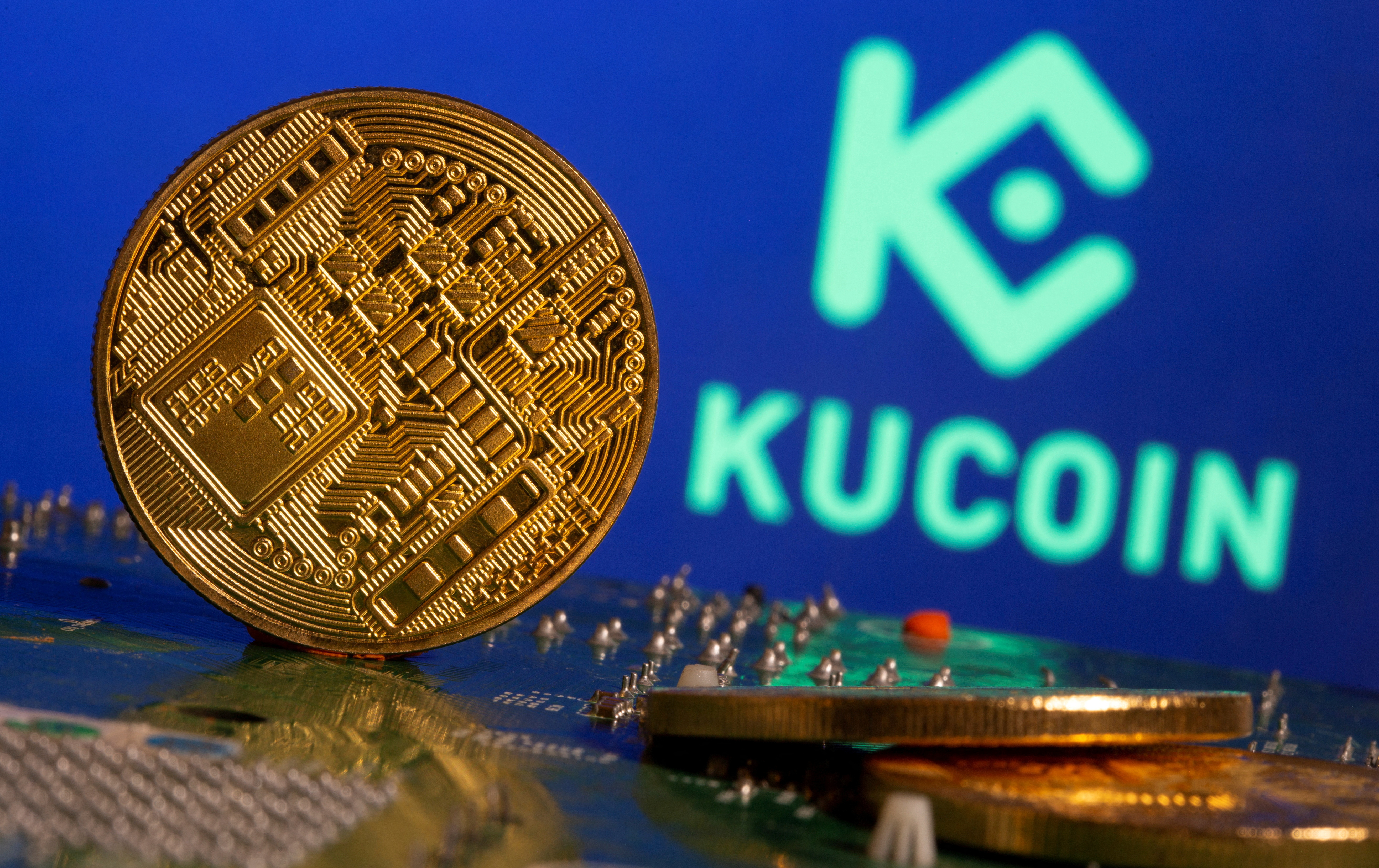 Representations of cryptocurrency is seen in front of a Kucoin logo in this illustration