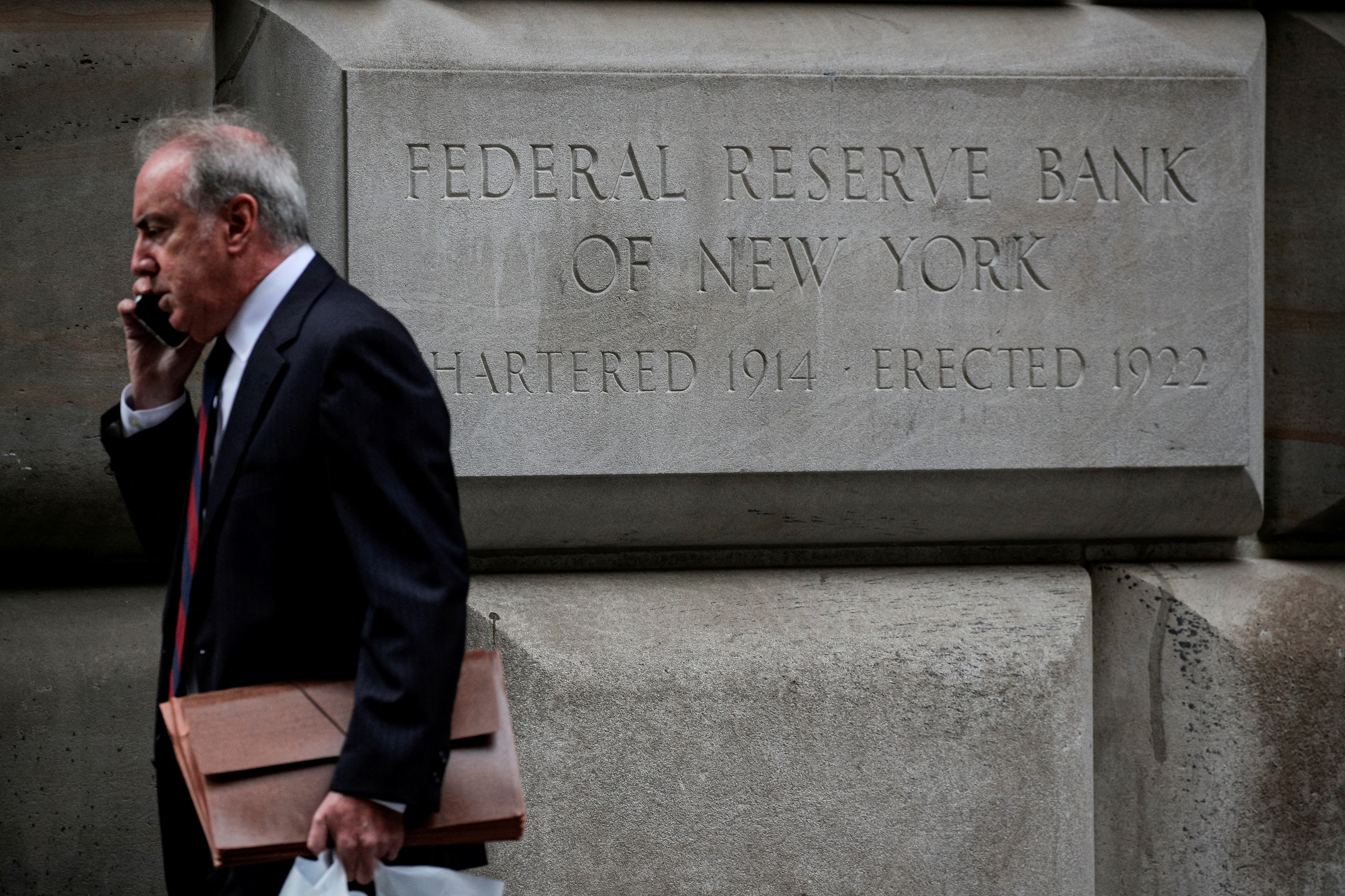 A man walks outside the Federal Reserve Bank of New York