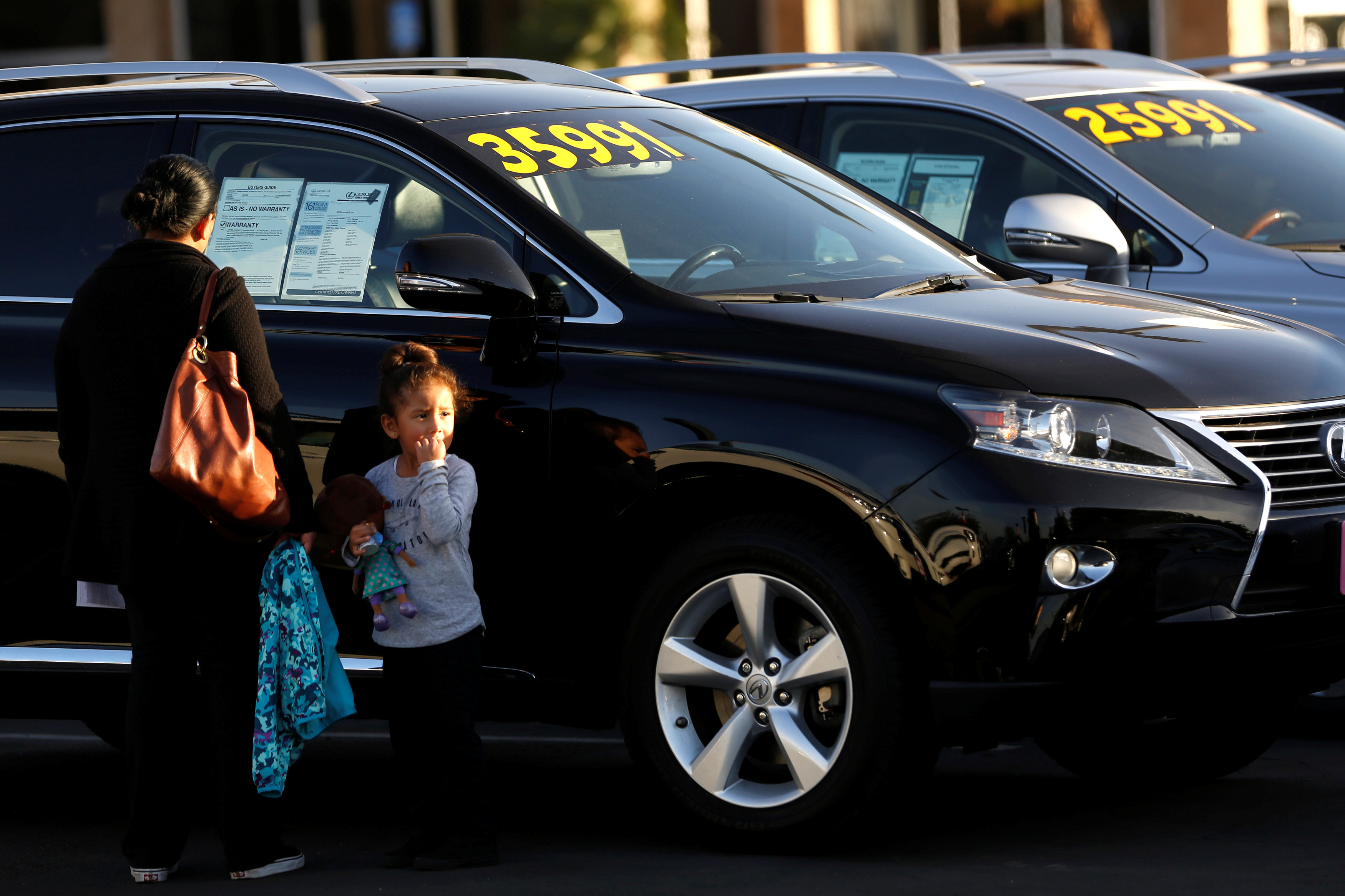 People look at vehicles for sale on the lot at AutoNation Toyota dealership in Cerritos