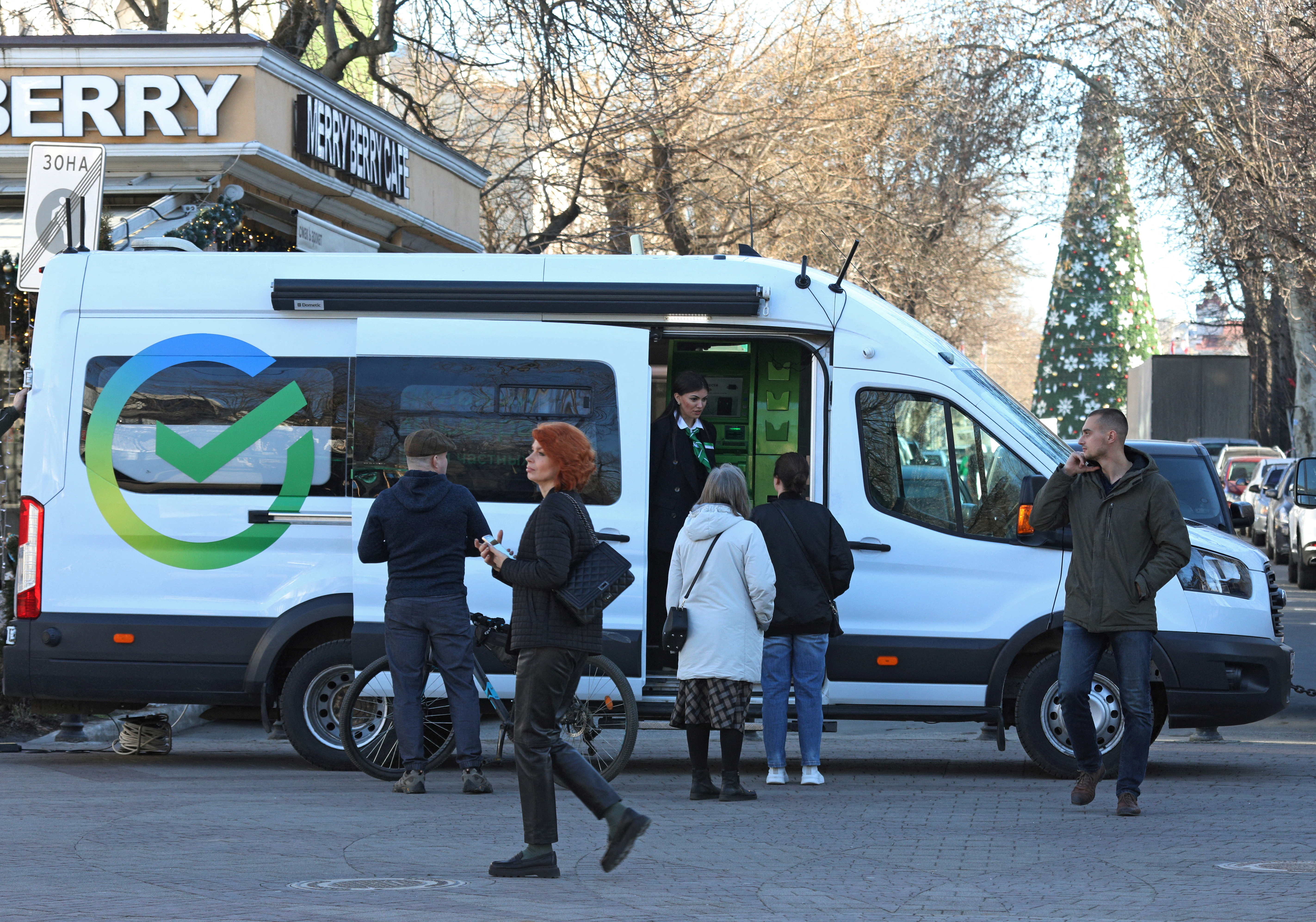 People talk to a bank employee at a mobile office of Sberbank in Simferopol