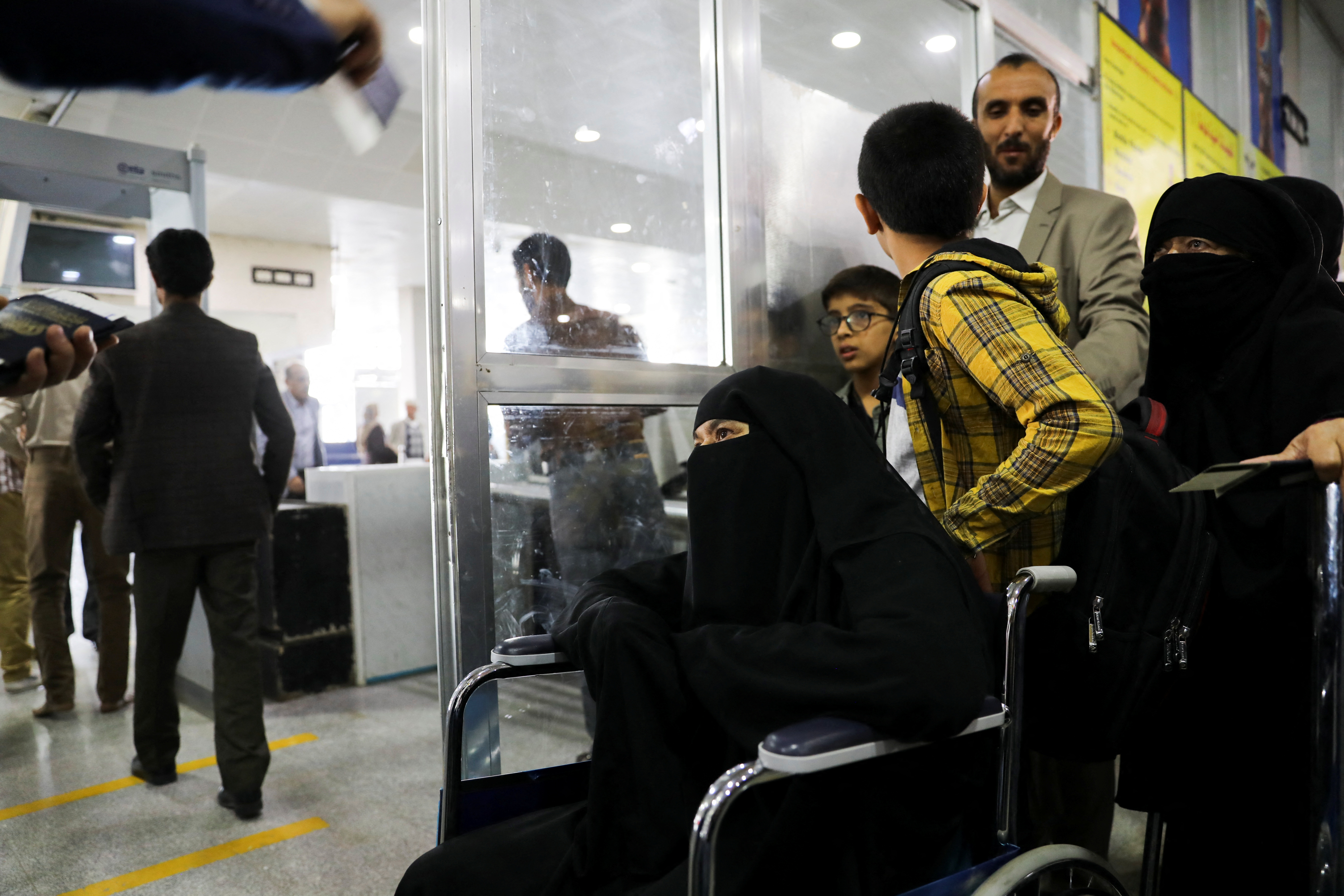People queue at the departures lounge to board the first commercial flight to be operated from Sanaa Airport, in Sanaa