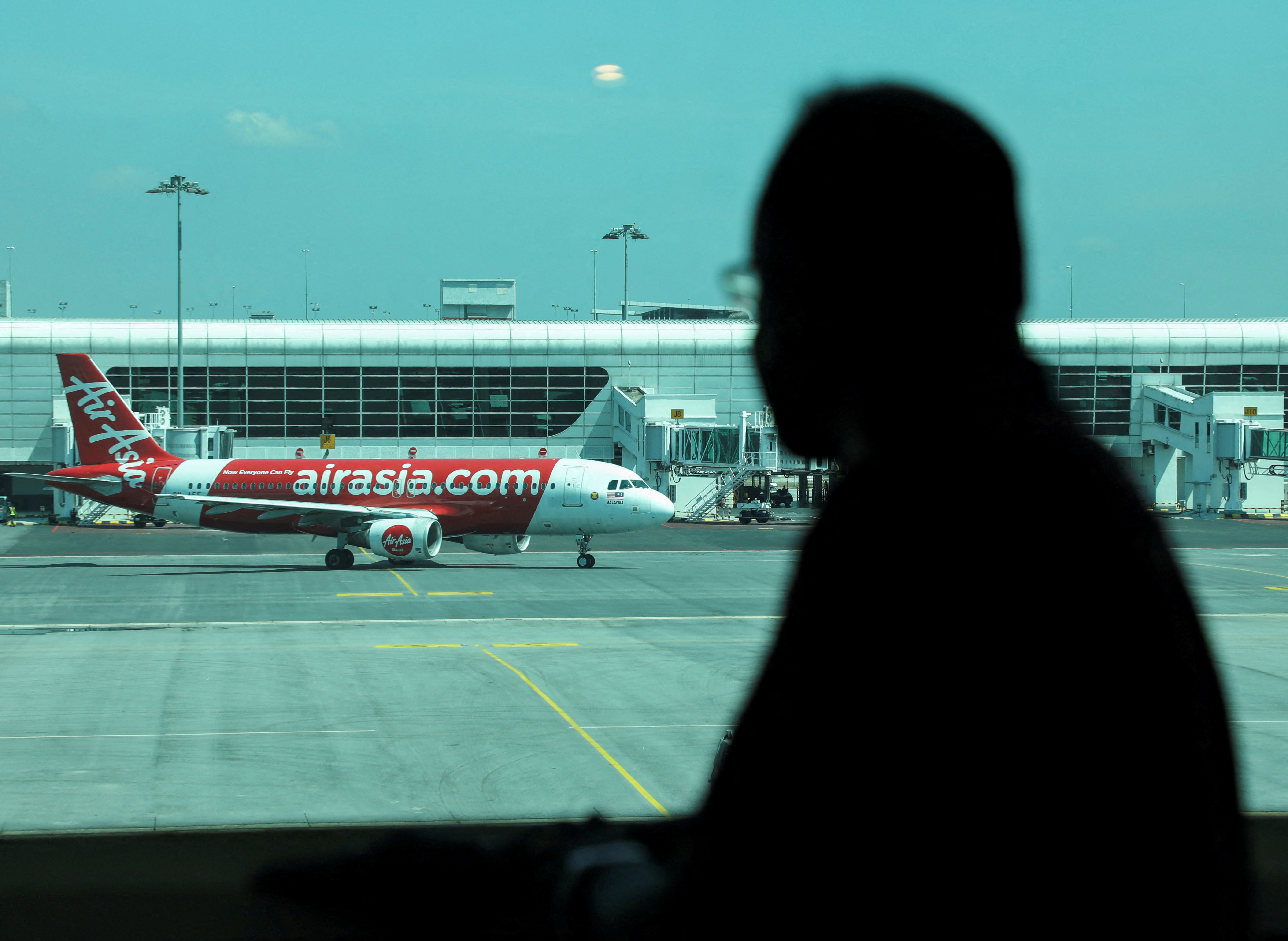 A traveller looks out at an aircraft as he waiting for his flight at Kuala Lumpur International Airport 2 (KLIA2) in Sepang