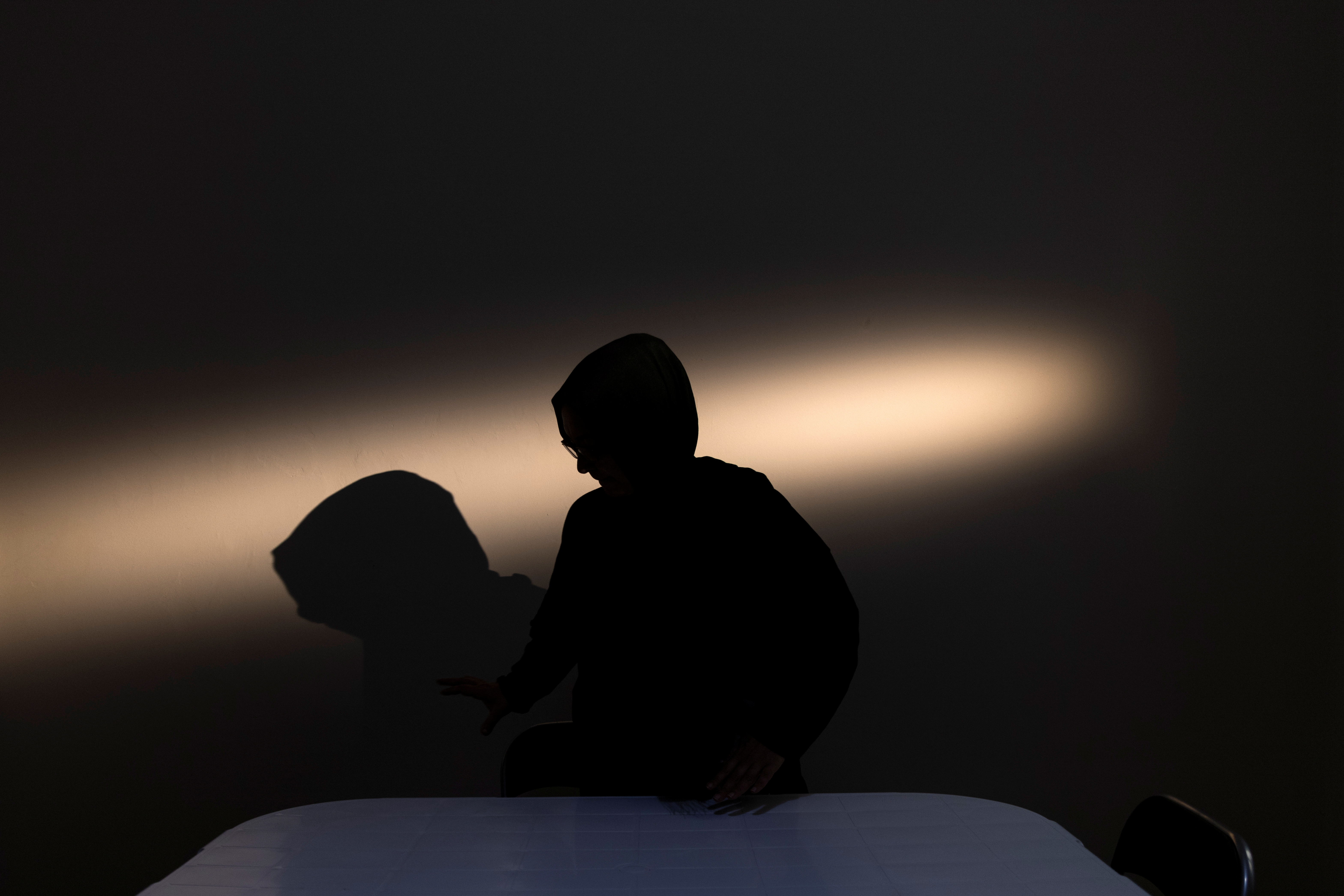 Afghan judge Friba Quraishi is silhouetted in her apartment in Athens