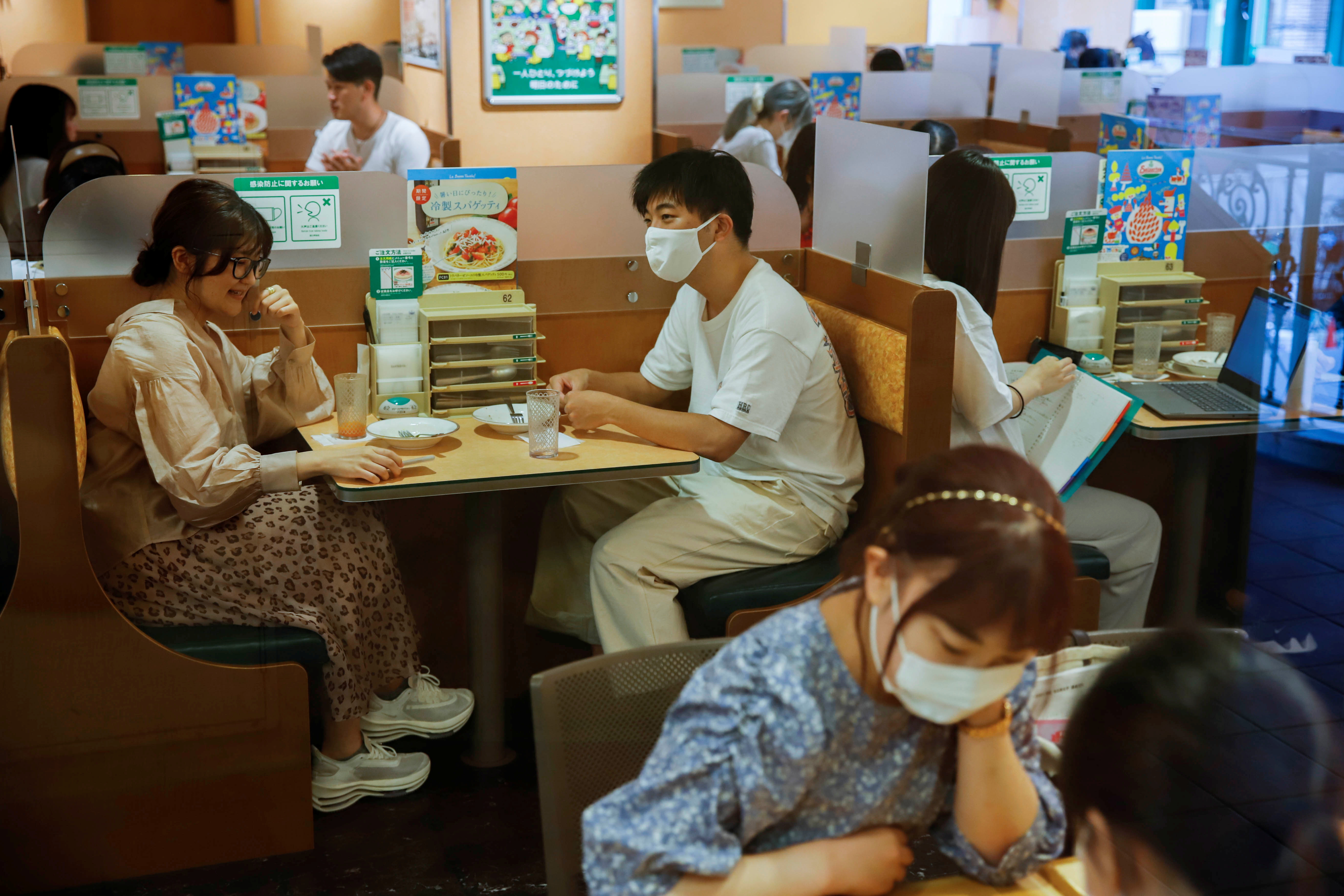 People sit in a restaurant using plexiglass separators to protect customers from coronavirus (COVID-19) disease in the Shibuya area of Tokyo