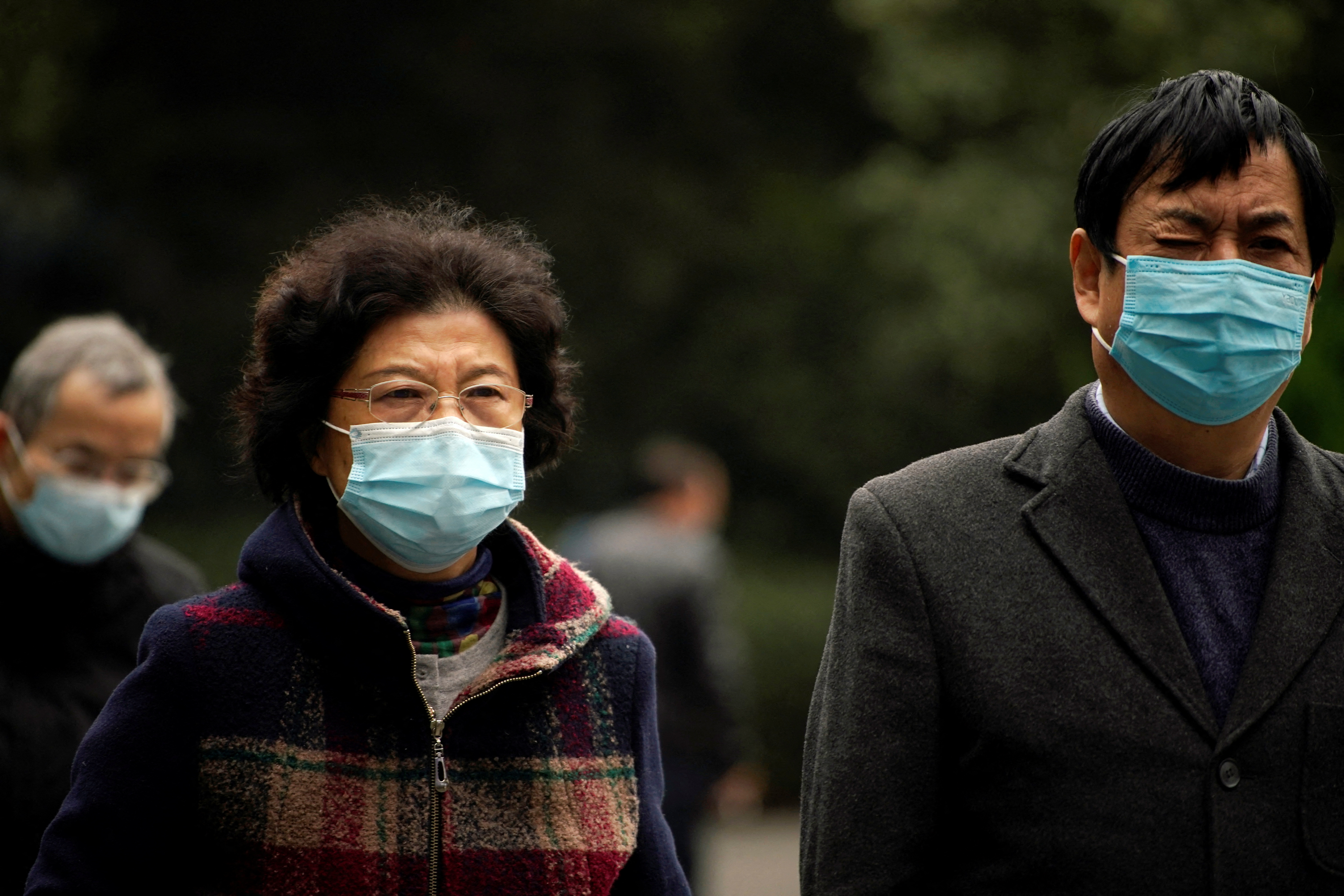 People wearing face masks following the COVID-19 outbreak walk on a street in Shanghai