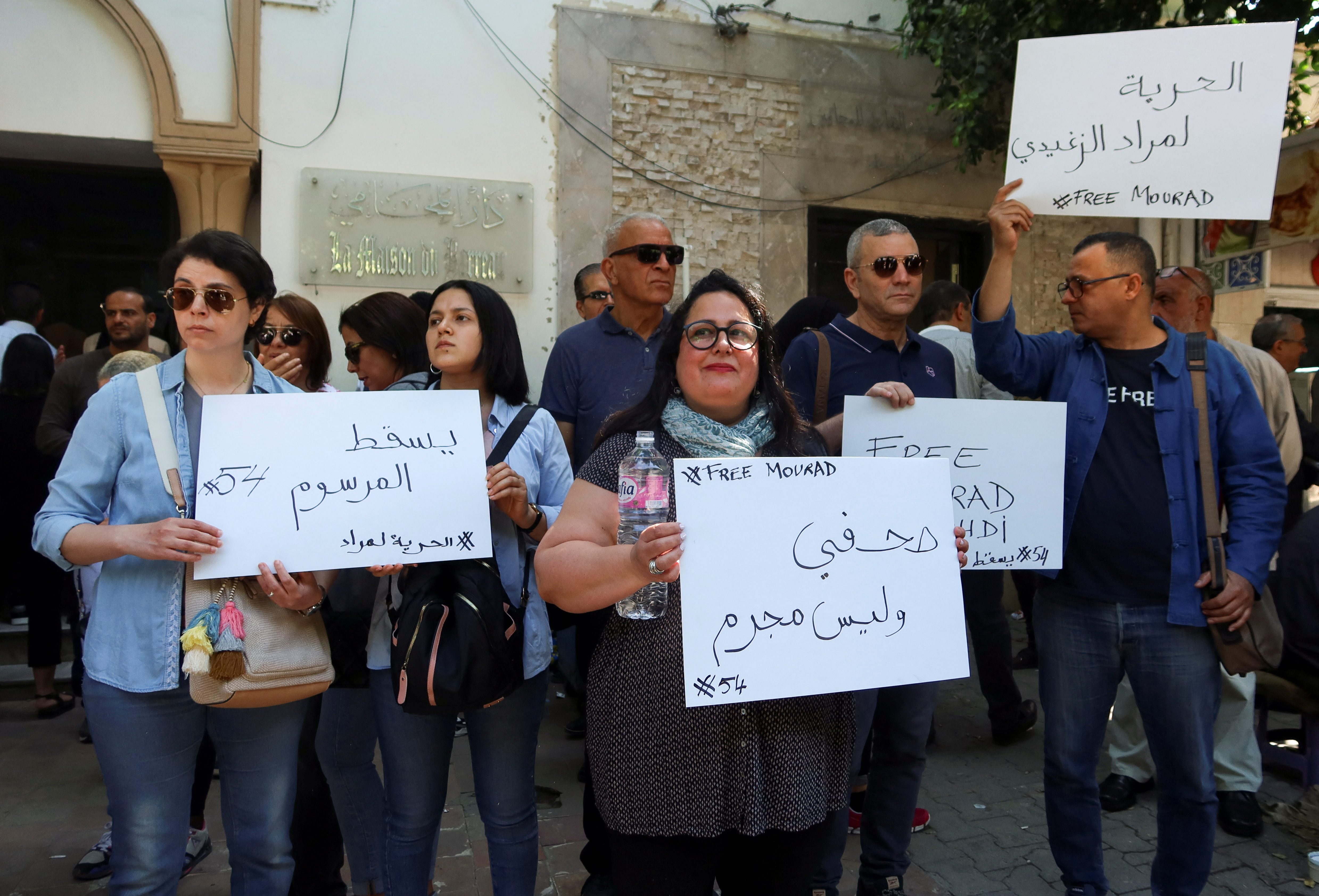 Relatives of radio journalist Mourad Zghidi carry banners as they call for his release in Tunis
