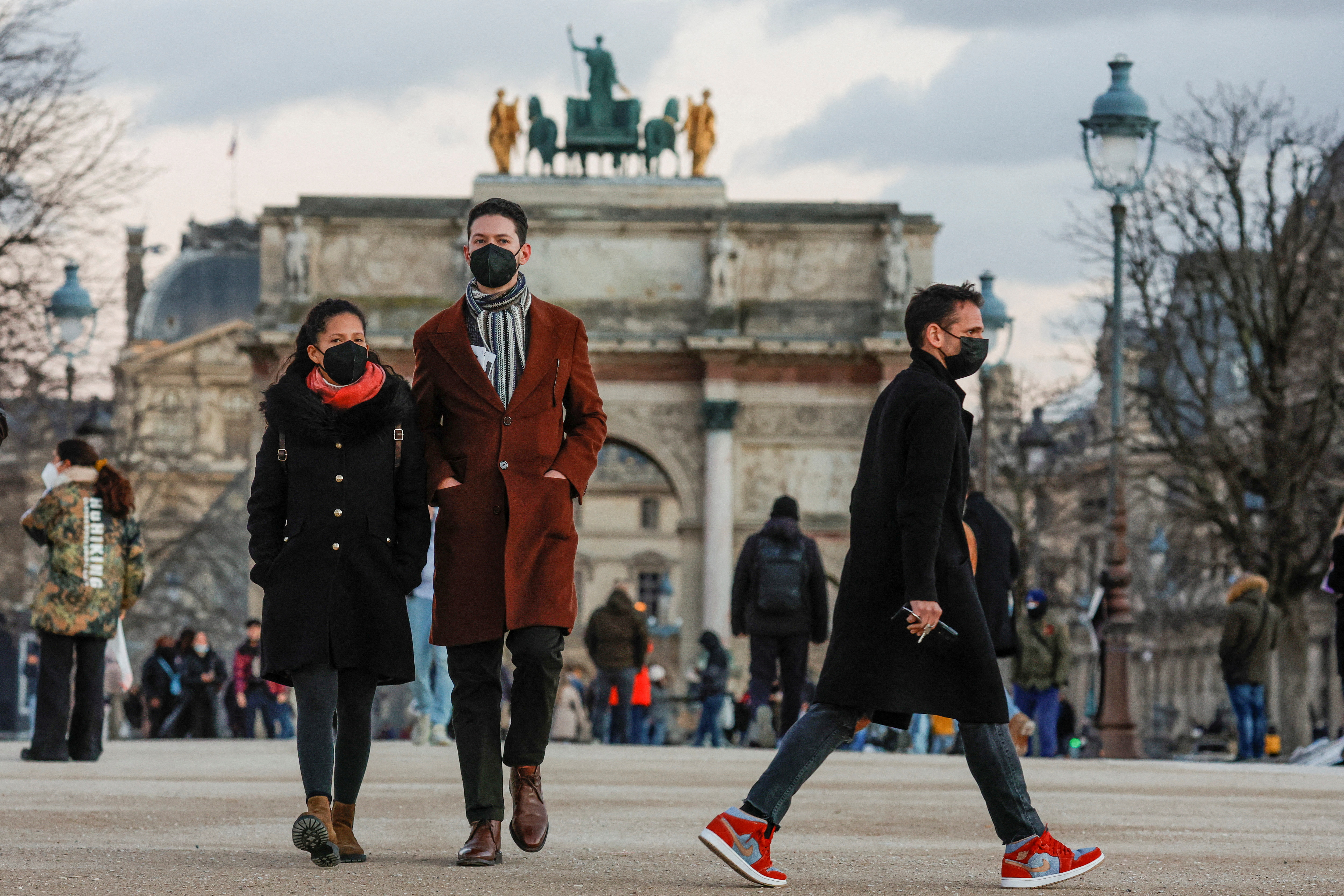 Folk som har på seg beskyttende ansiktsmasker går i Tuileries-hagene i Paris midt i utbruddet av koronavirussykdommen (COVID-19) i Frankrike, 5. januar 2022. REUTERS/Gonzalo Fuentes