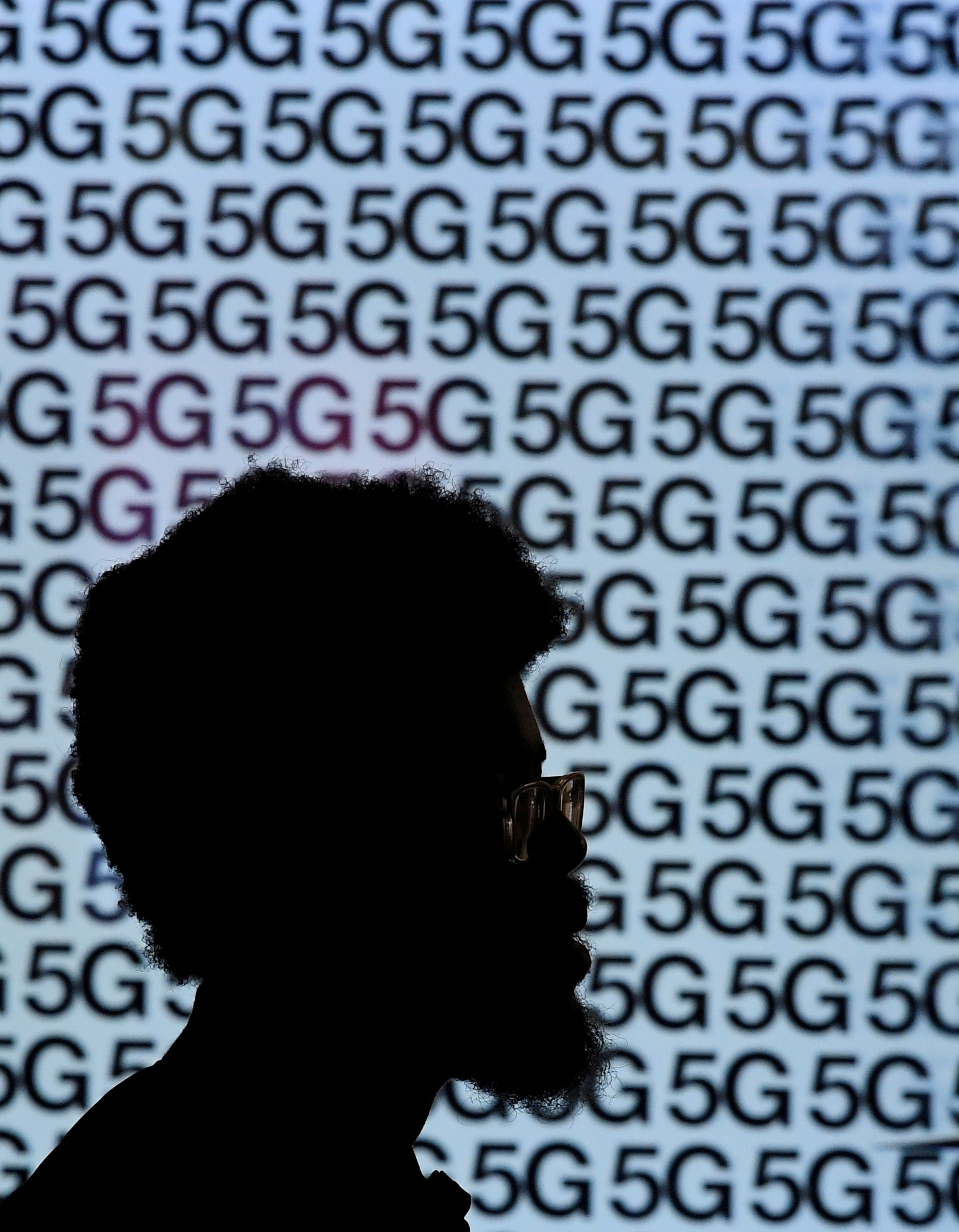 A man walks past an advertisement promoting the 5G data network at a mobile phone store in London, Britain, January 28, 2020. REUTERS/Toby Melville/File Photo