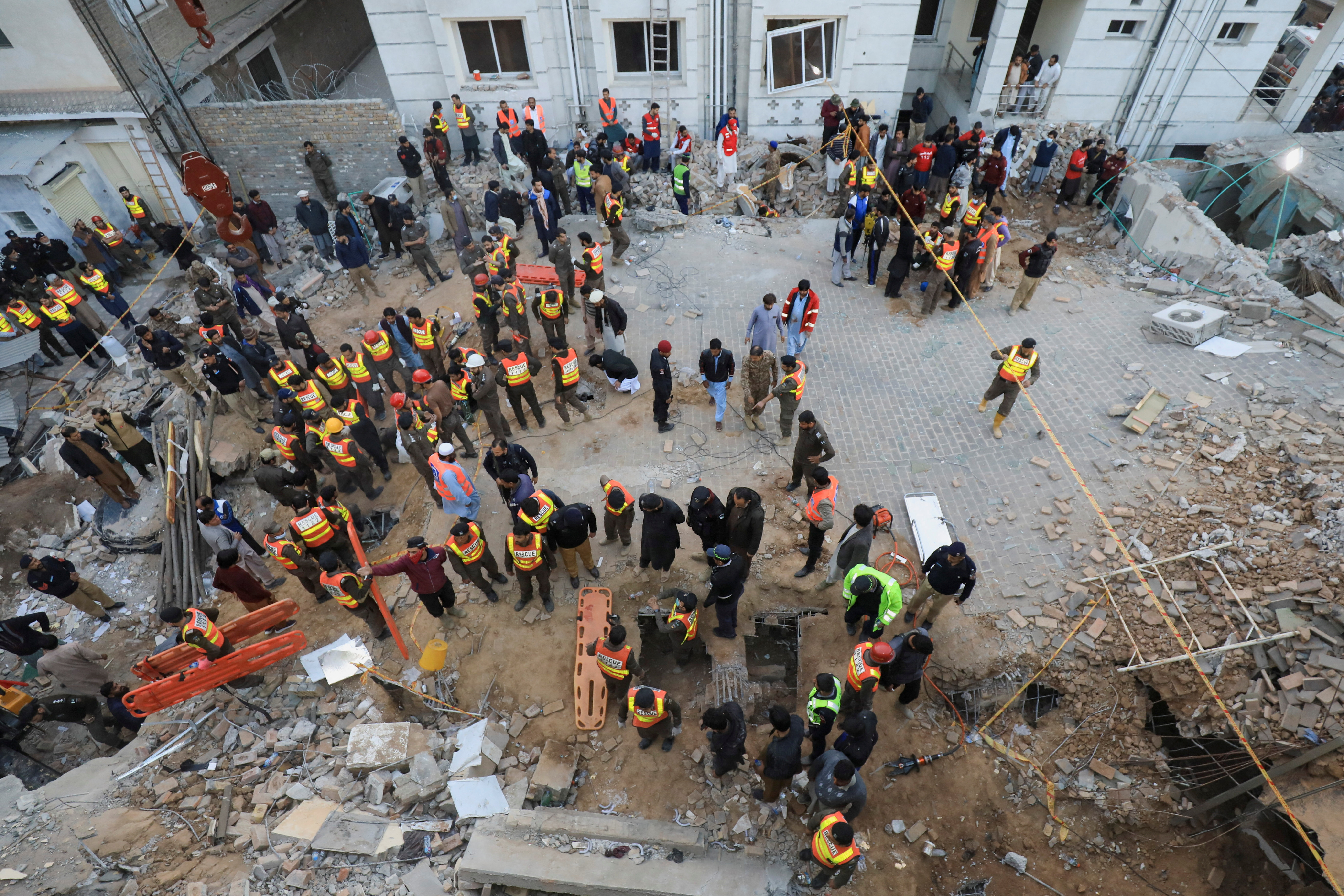 Rescue workers search for survivors after a suicide bombing at a mosque in Peshawar
