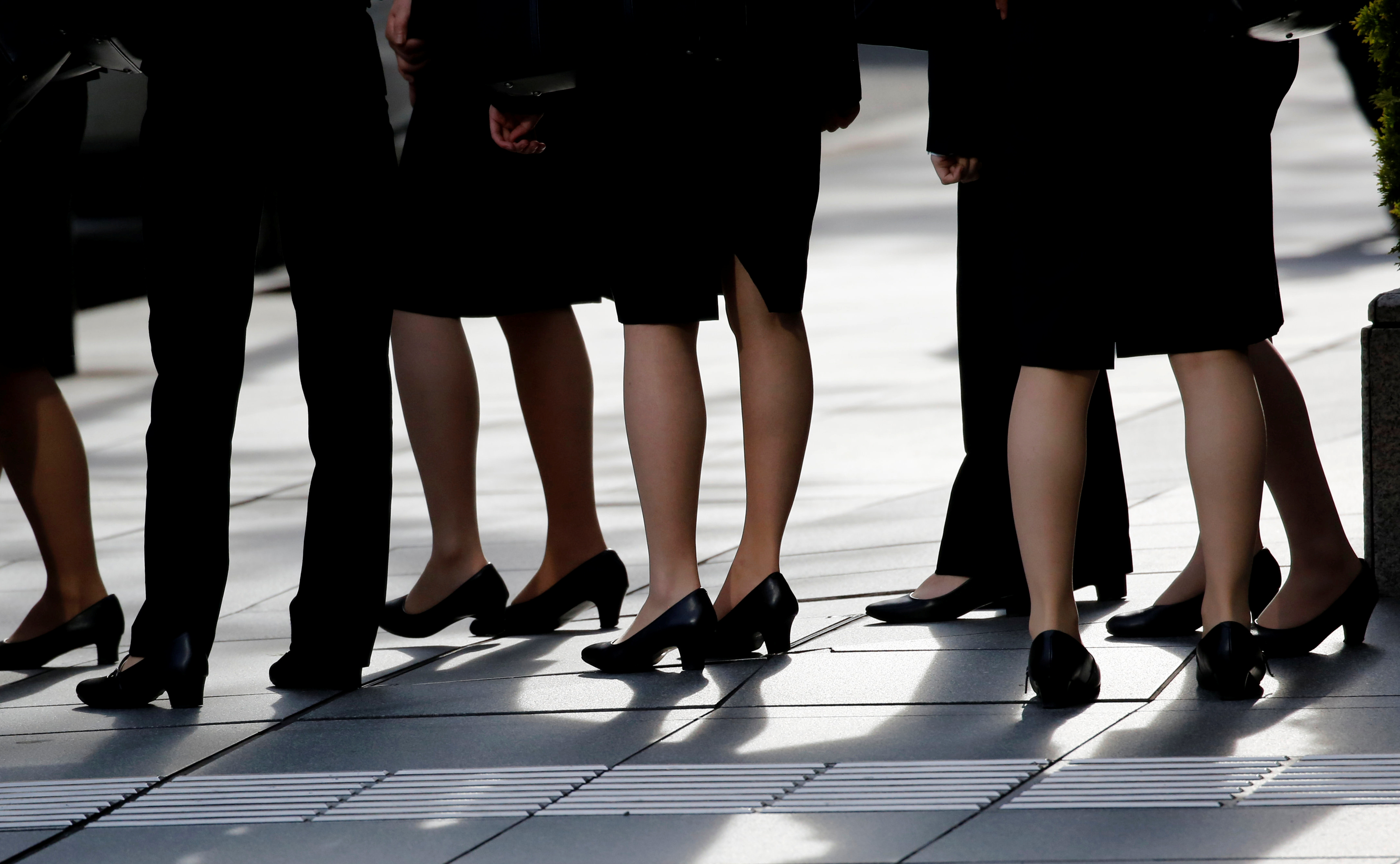 Female office workers wearing high heels, clothes and bags of the same colour are seen at a business district in Tokyo
