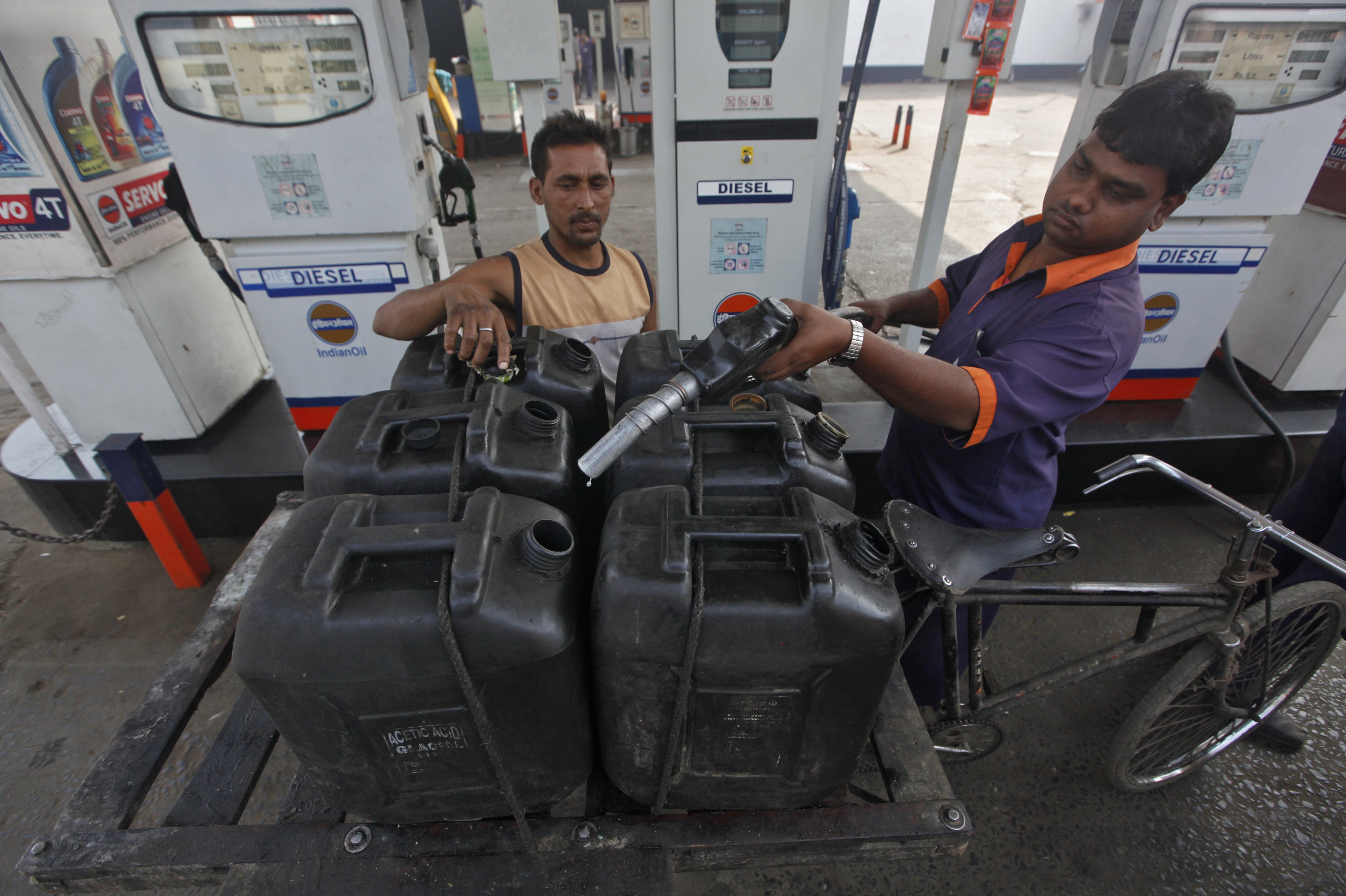 A worker prepares to fill a jerry-can at a fuel station in Kolkata