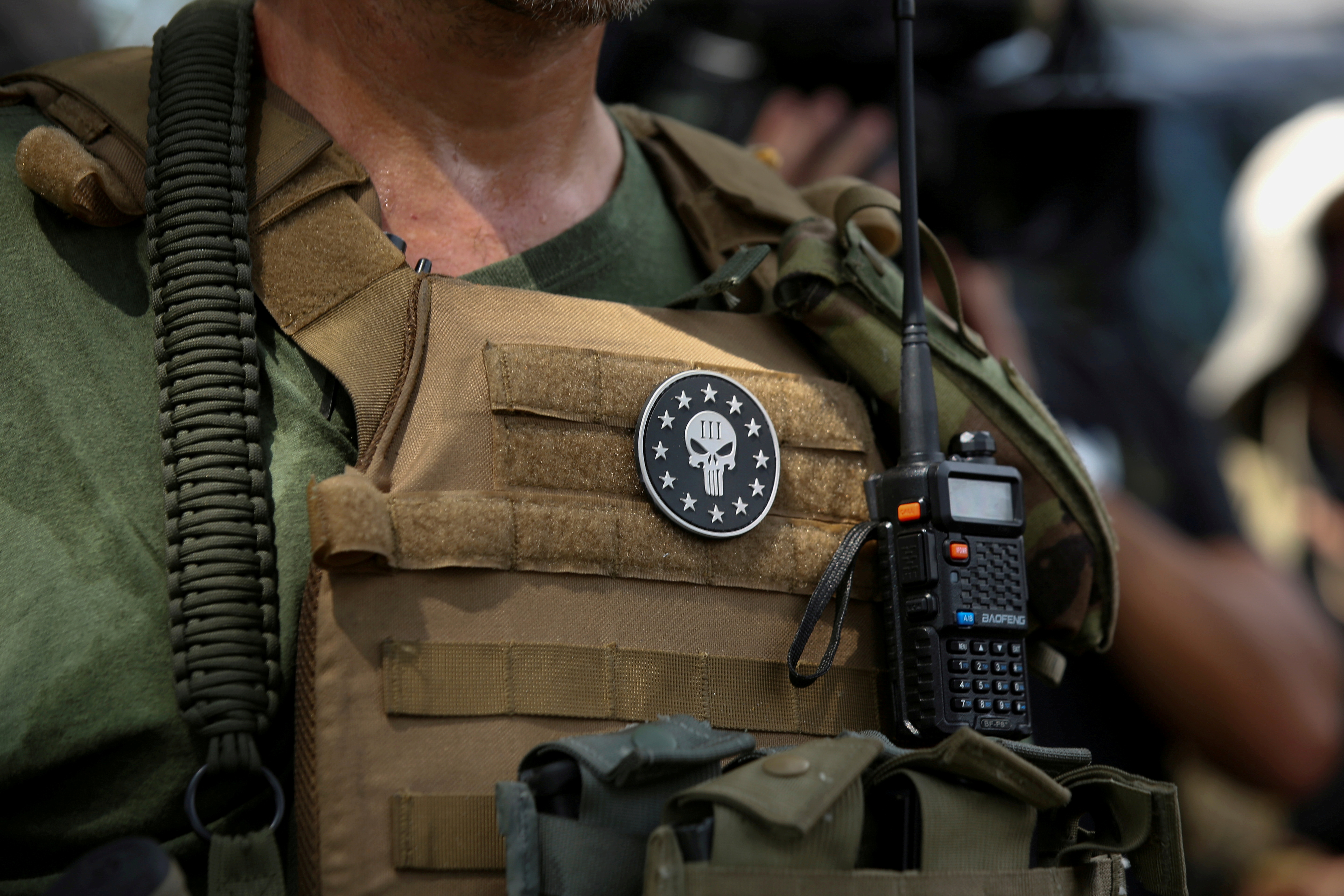 A militia member with body armor and a Three Percenters militia patch stands in Stone Mountain as various militia groups stage rallies at Stone Mountain, Georgia, U.S. August 15, 2020.  REUTERS/Dustin Chambers/File Photo