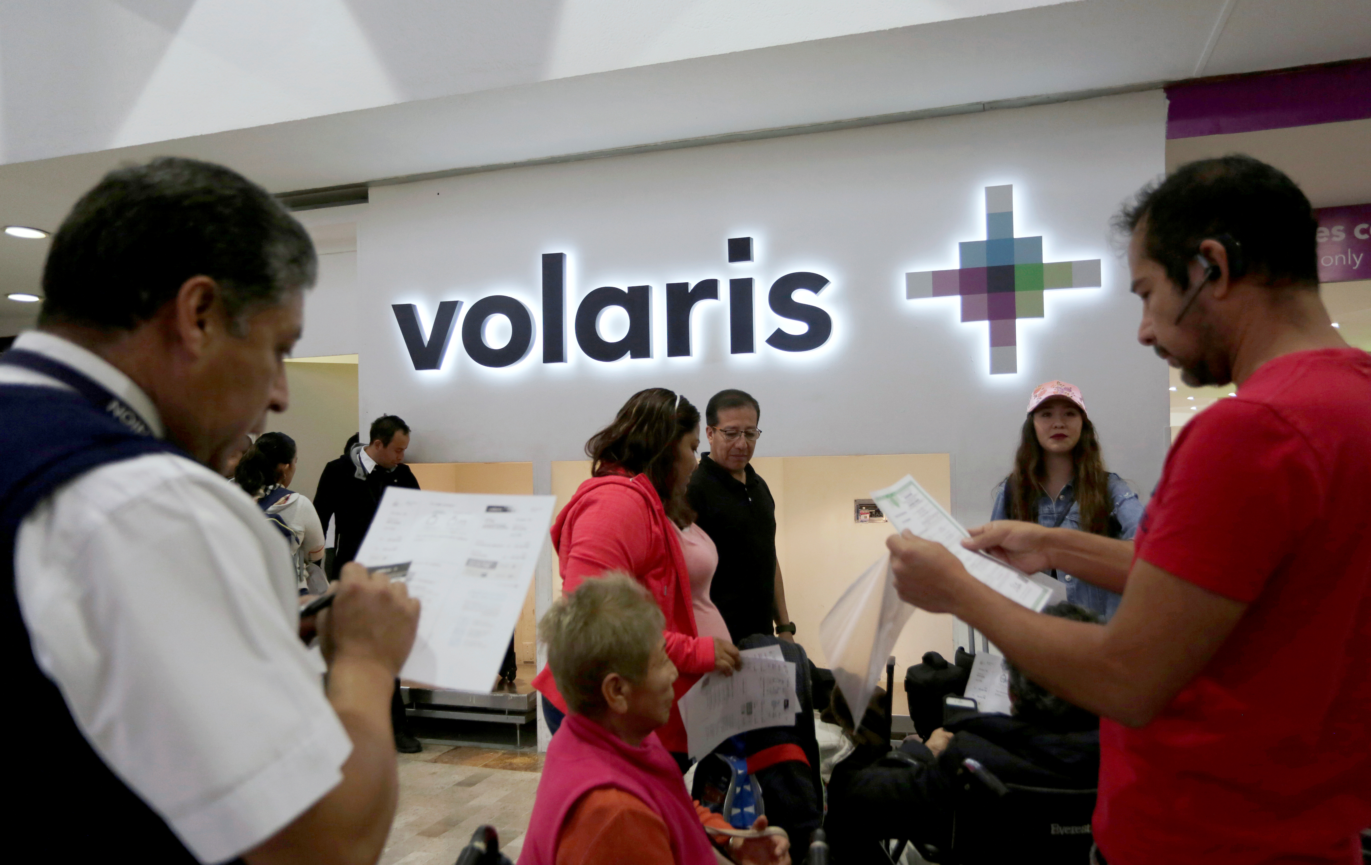 A passenger (R) talks to an airline employee of the Mexican low-cost air carrier Volaris at Benito Juarez International Airport in Mexico City, Mexico January 10, 2018. Picture taken January 10, 2018. REUTERS/Daniel Becerril/Files