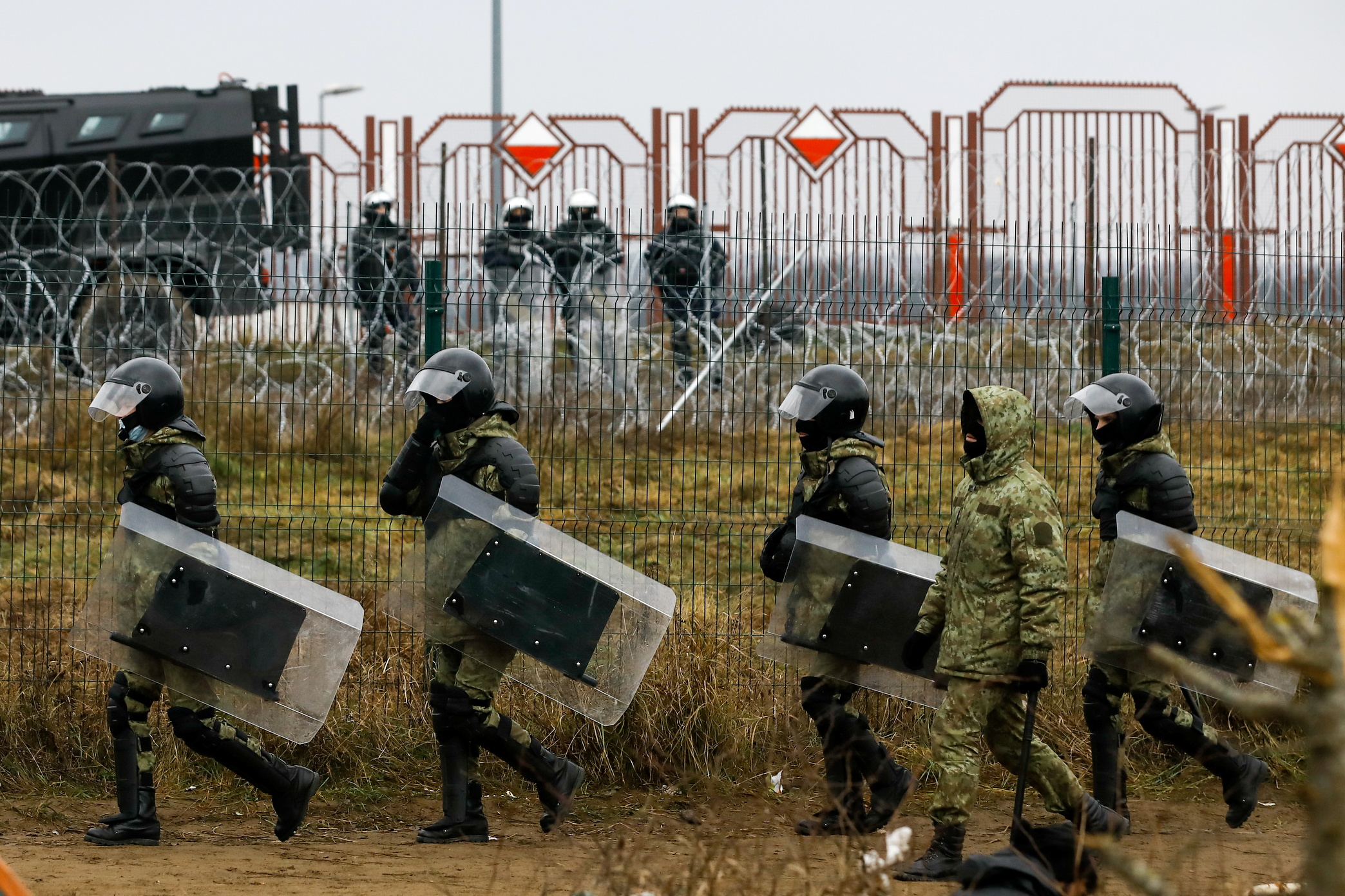 Personeli bjellorus i zbatimit të ligjit ecën në një kamp pranë pikës së kontrollit Bruzgi-Kuznica në kufirin Bjellorusiano-Polak në rajonin Grodno, Bjellorusi, 18 nëntor 2021. REUTERS/Kacper Pempel