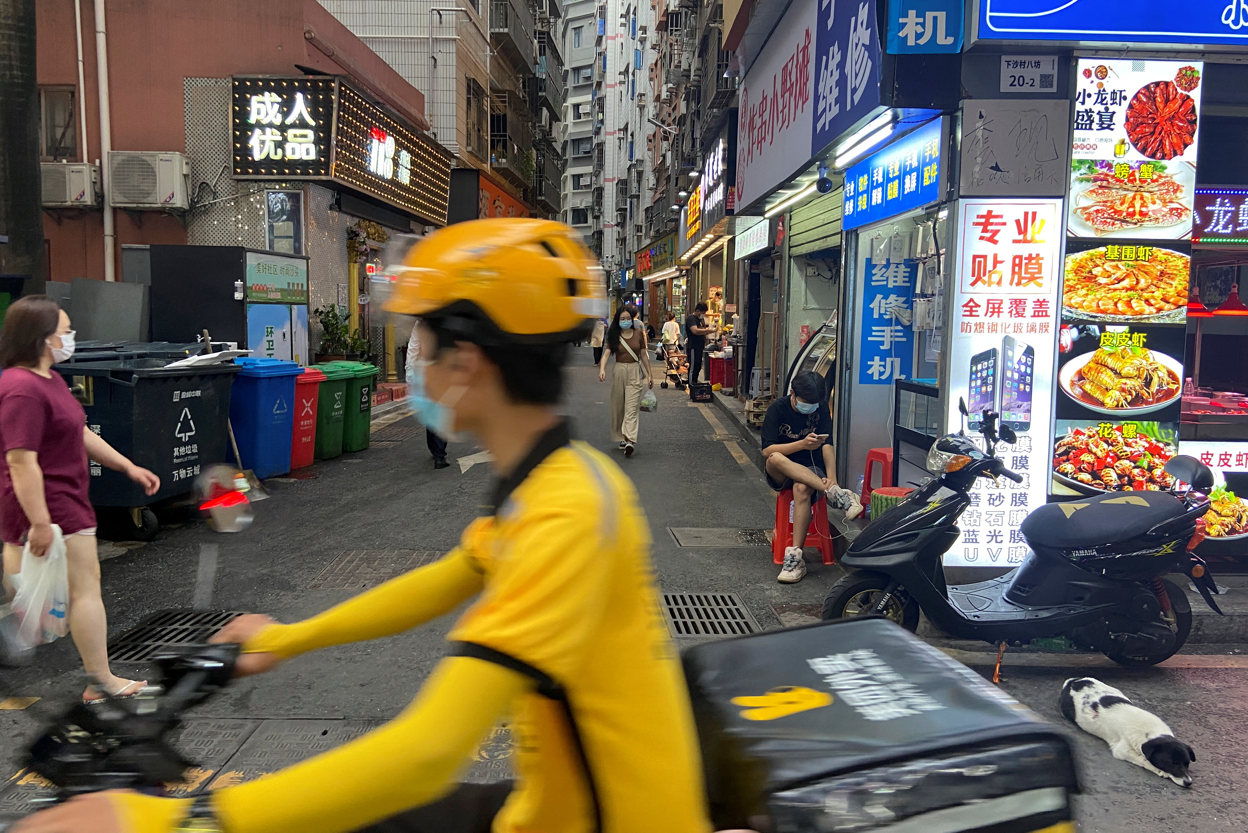 Food delivery worker rides past an urban village in Shenzhen