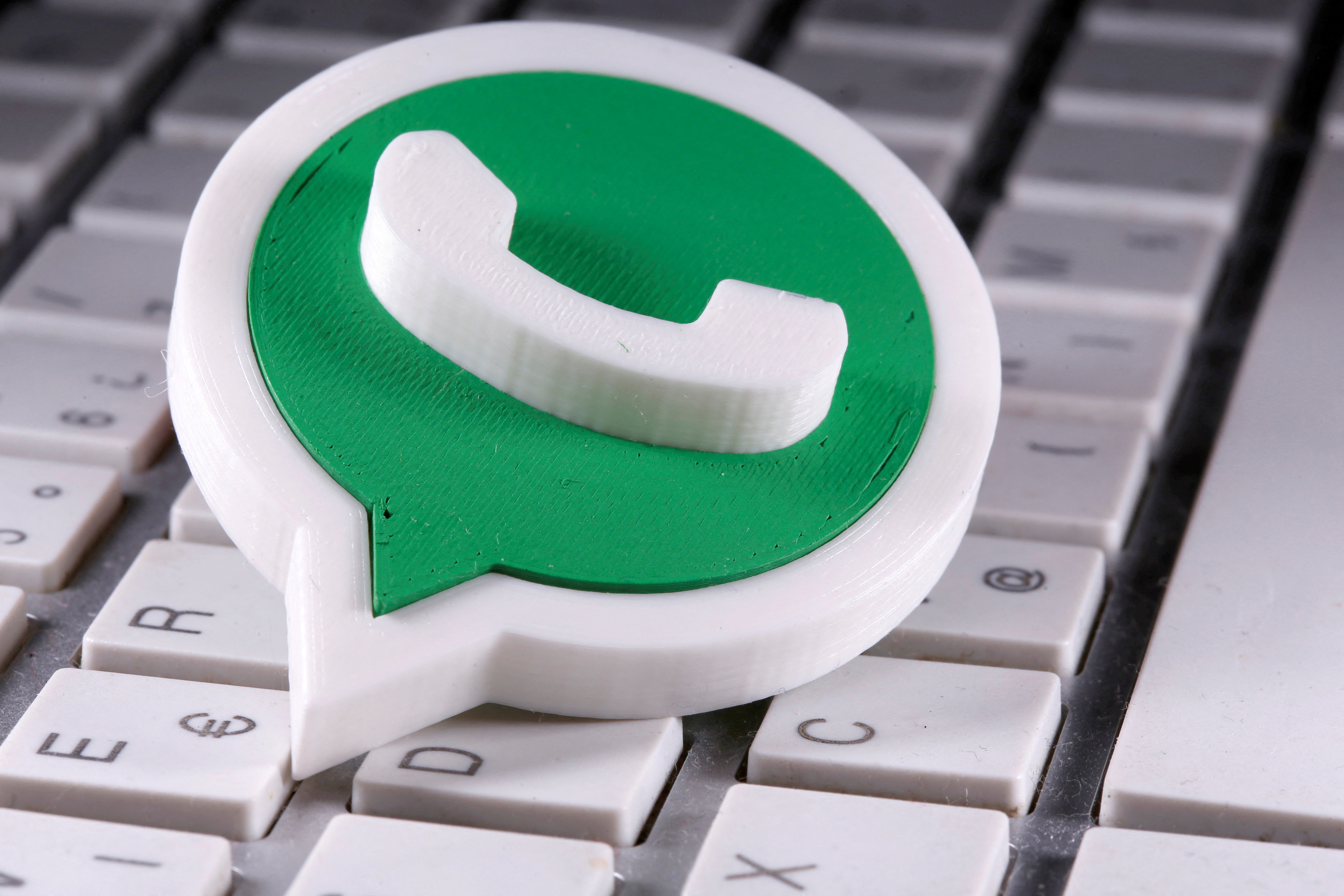 A 3D-printed Whatsapp logo is placed on the keyboard in this illustration taken