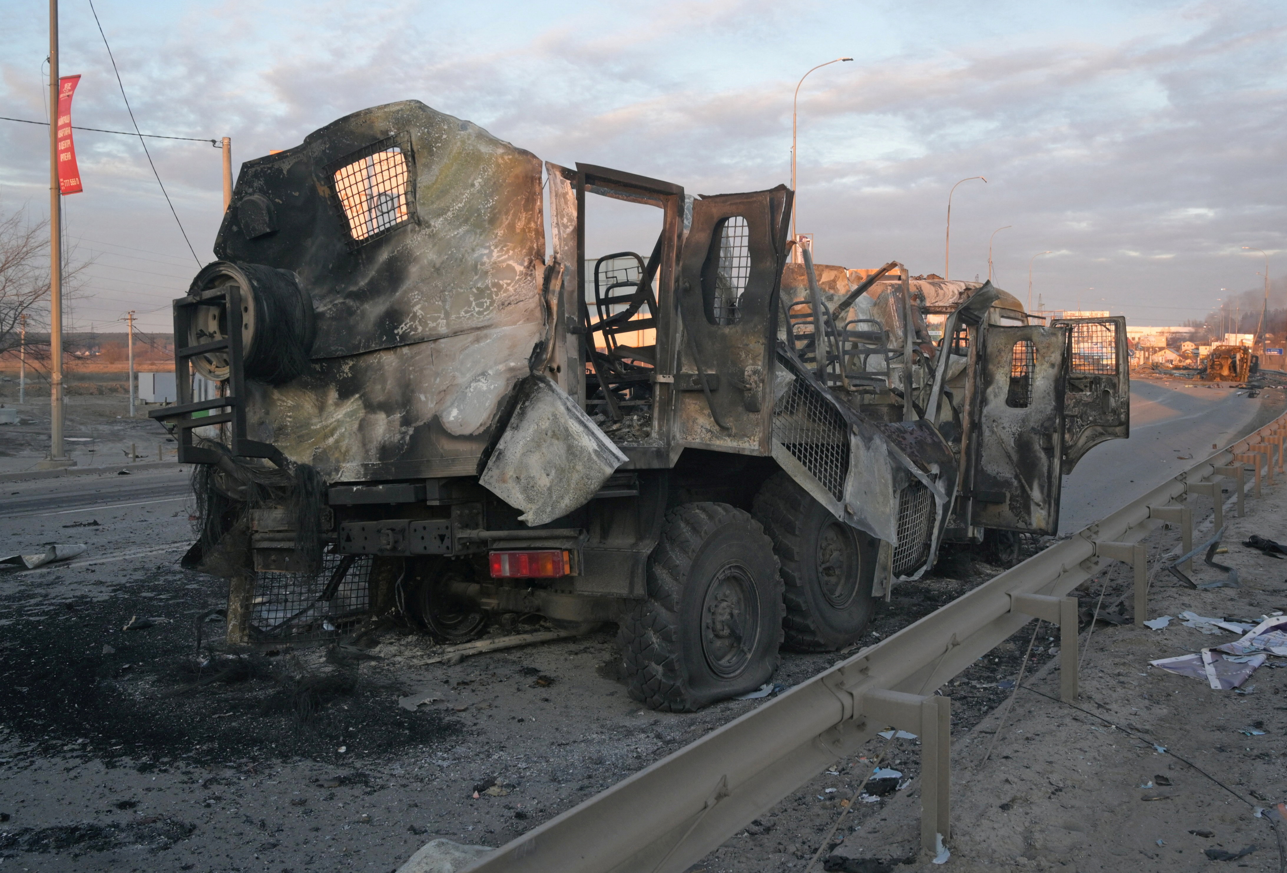 A charred military vehicle is seen on a road near Bucha
