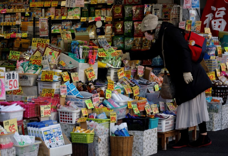 A woman chooses products at a drug store in Tokyo