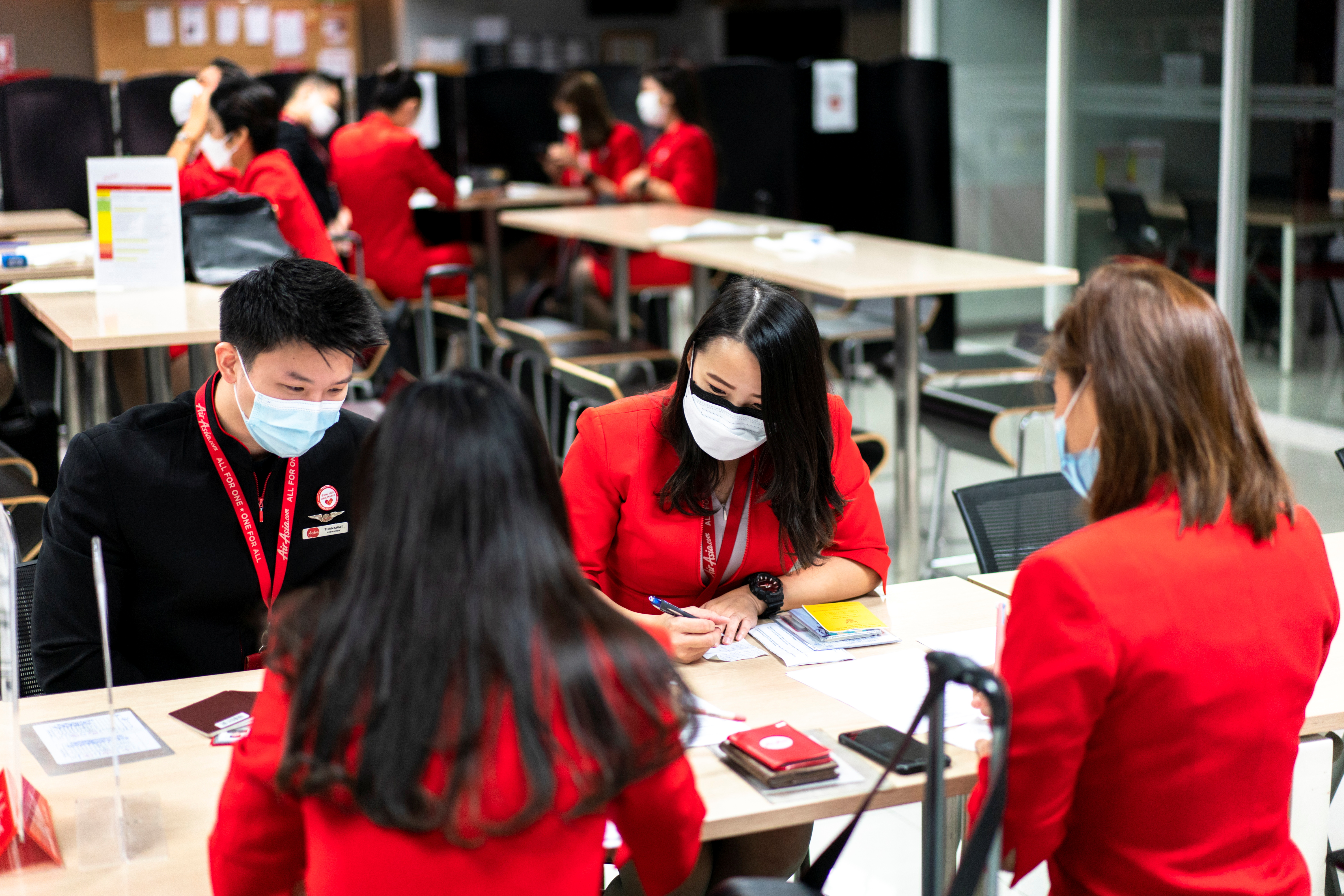Thai AirAsia cabin crew members wearing masks to prevent the spread of the coronavirus disease (COVID-19) study their domestic routes ahead of their flights, at Bangkok's Don Muang International Airport, Thailand, October 27, 2021. REUTERS/Athit Perawongmetha
