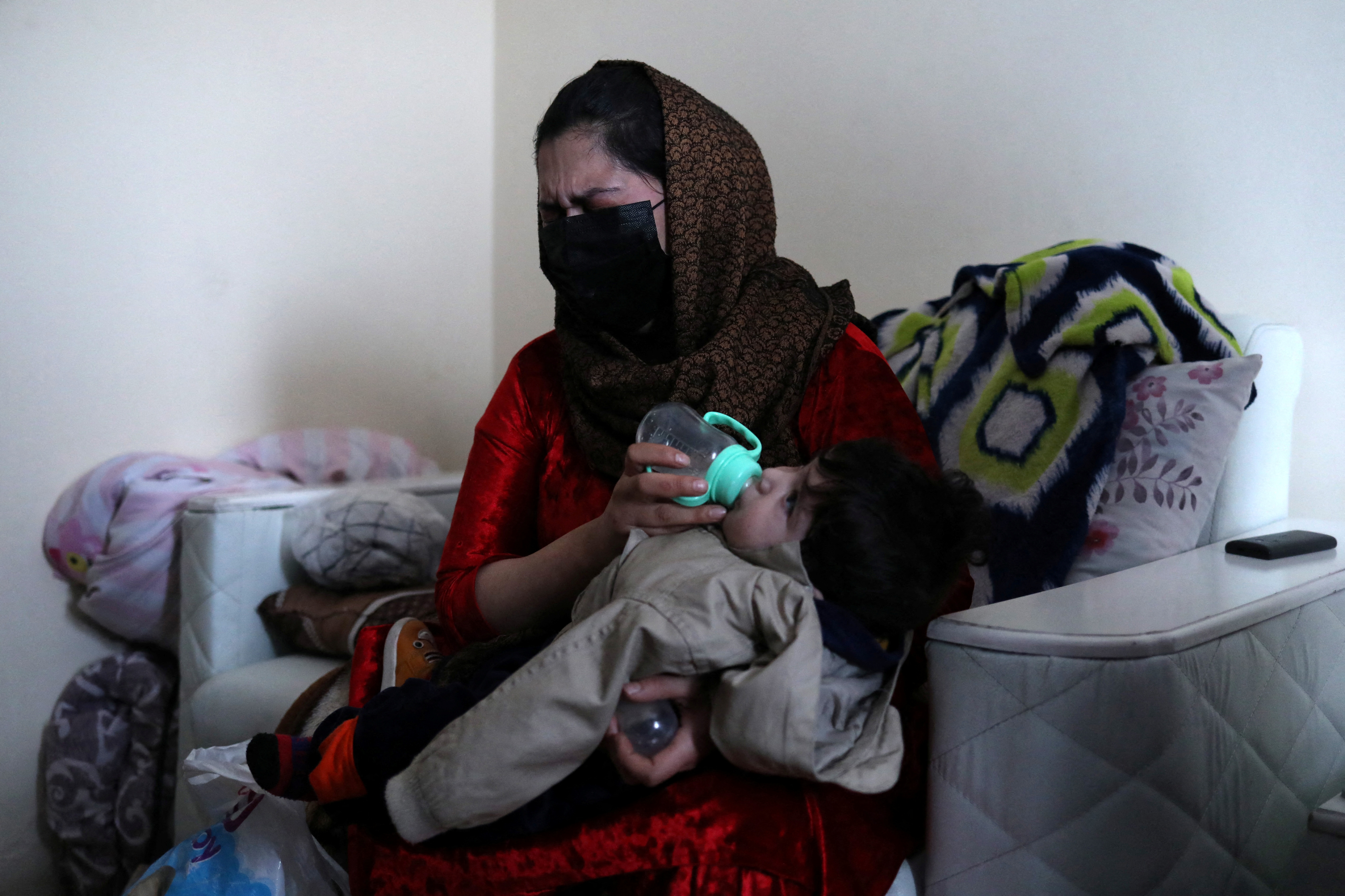 Farima Safi weeps as she feeds baby Sohail Ahmadi at her house in Kabul