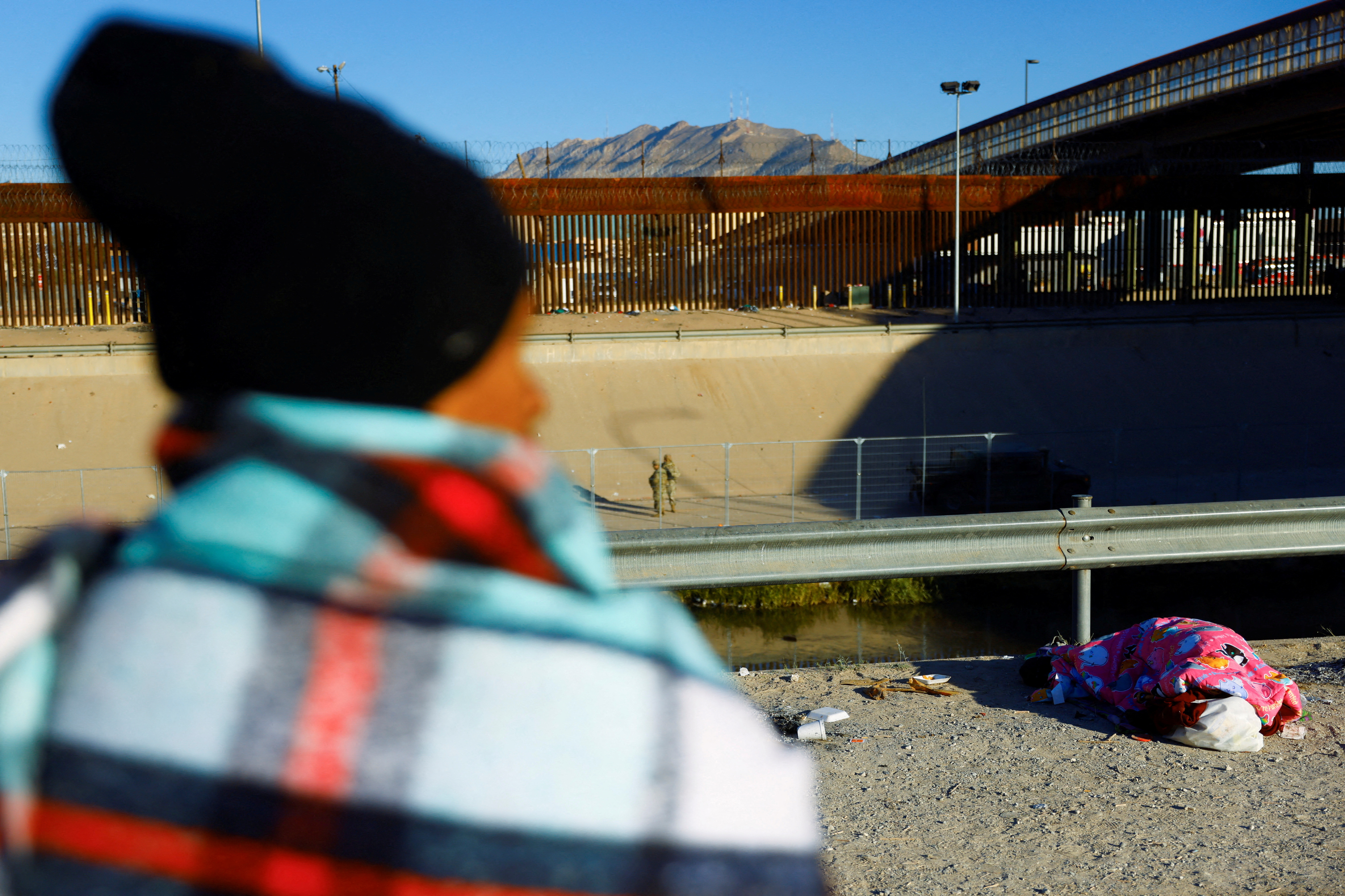 Asylum-seeking migrants rest near the Rio Bravo river, in Ciudad Juarez