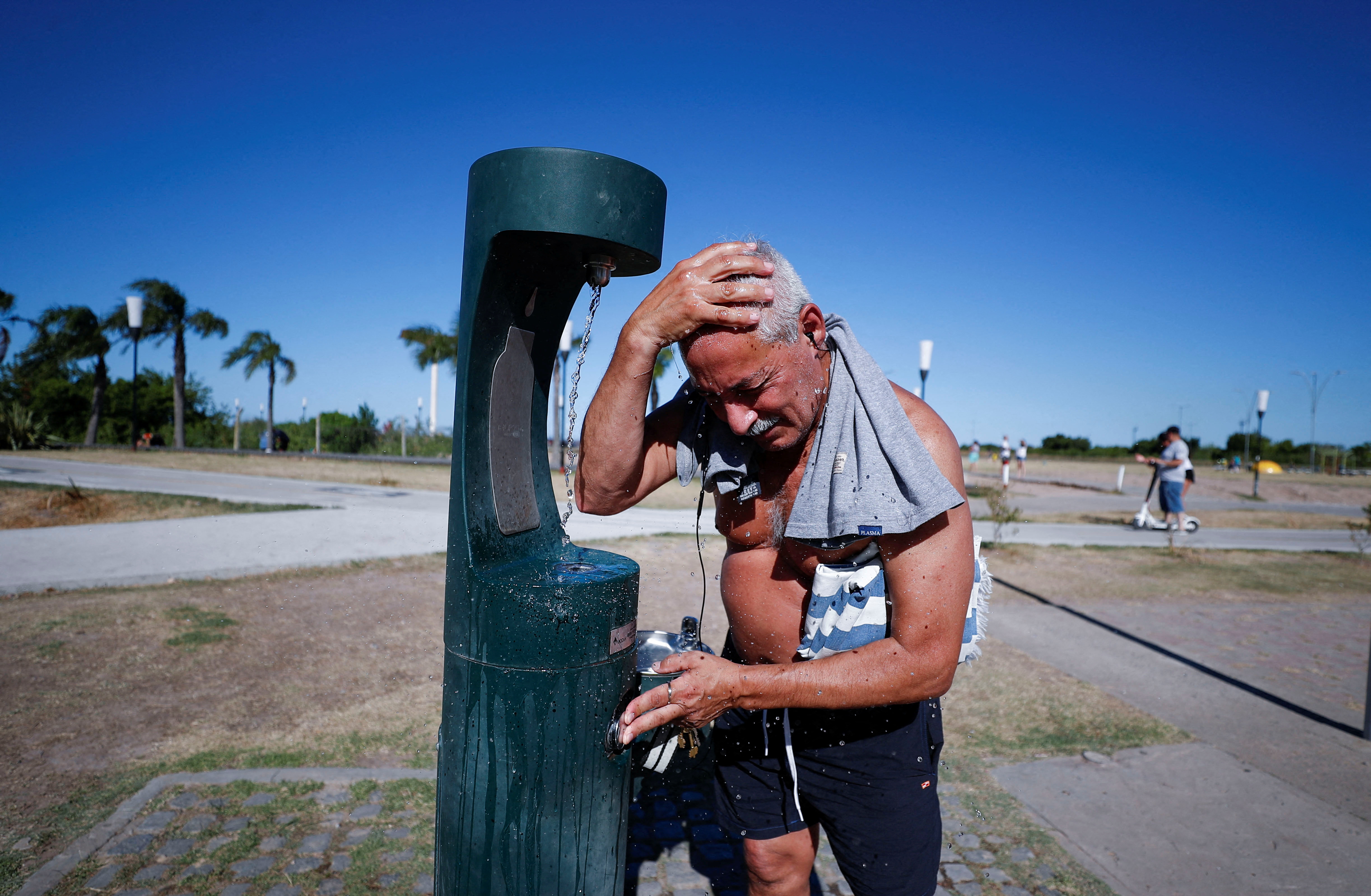 A man refreshes as he enjoys the day by the shore of the Rio de la Plata river during a heat wave amid a spike of the coronavirus disease (COVID-19) cases, in Buenos Aires, Argentina January 9, 2022. REUTERS/Agustin Marcarian