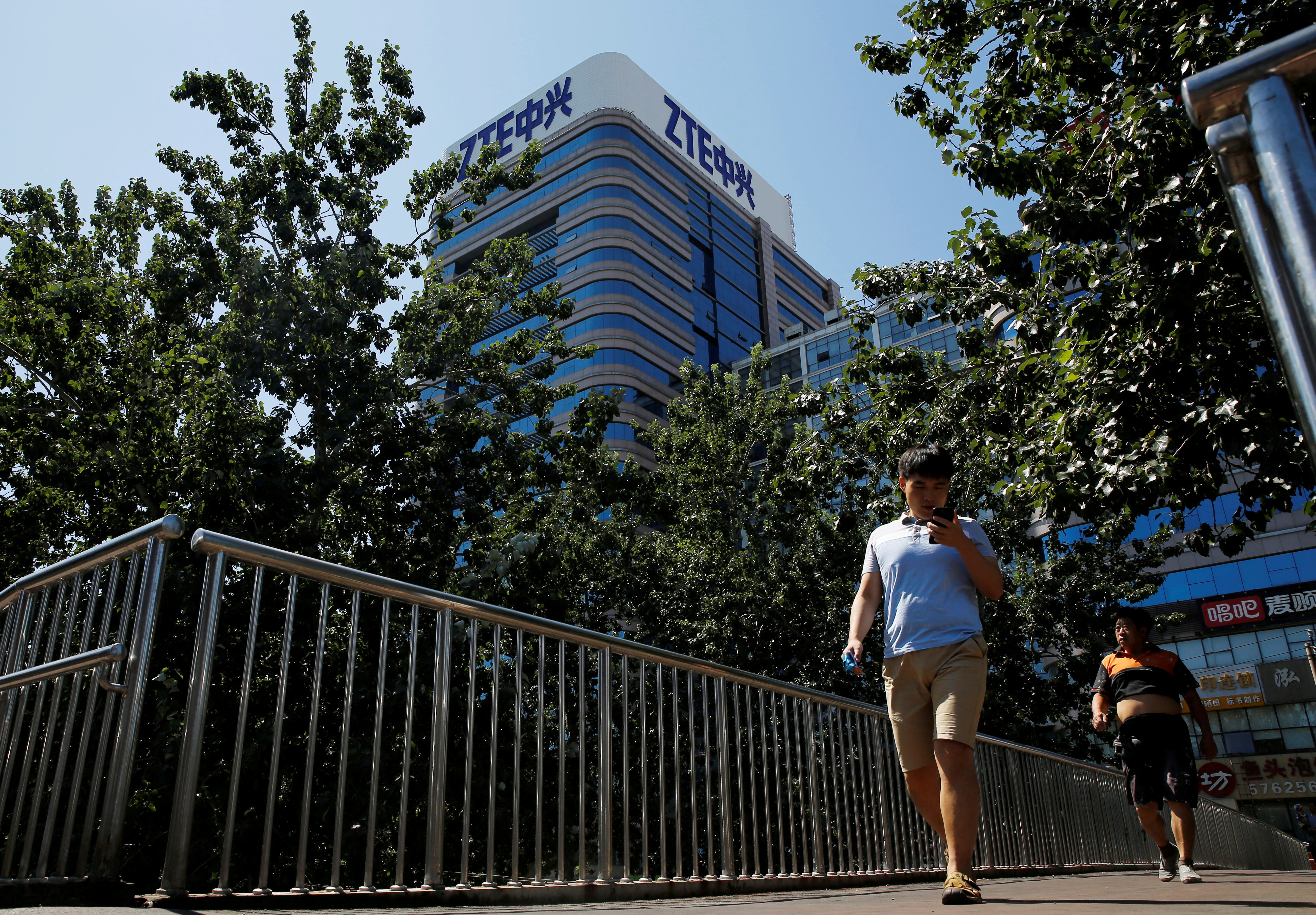 People walk past a building of China's ZTE Corp in Beijing