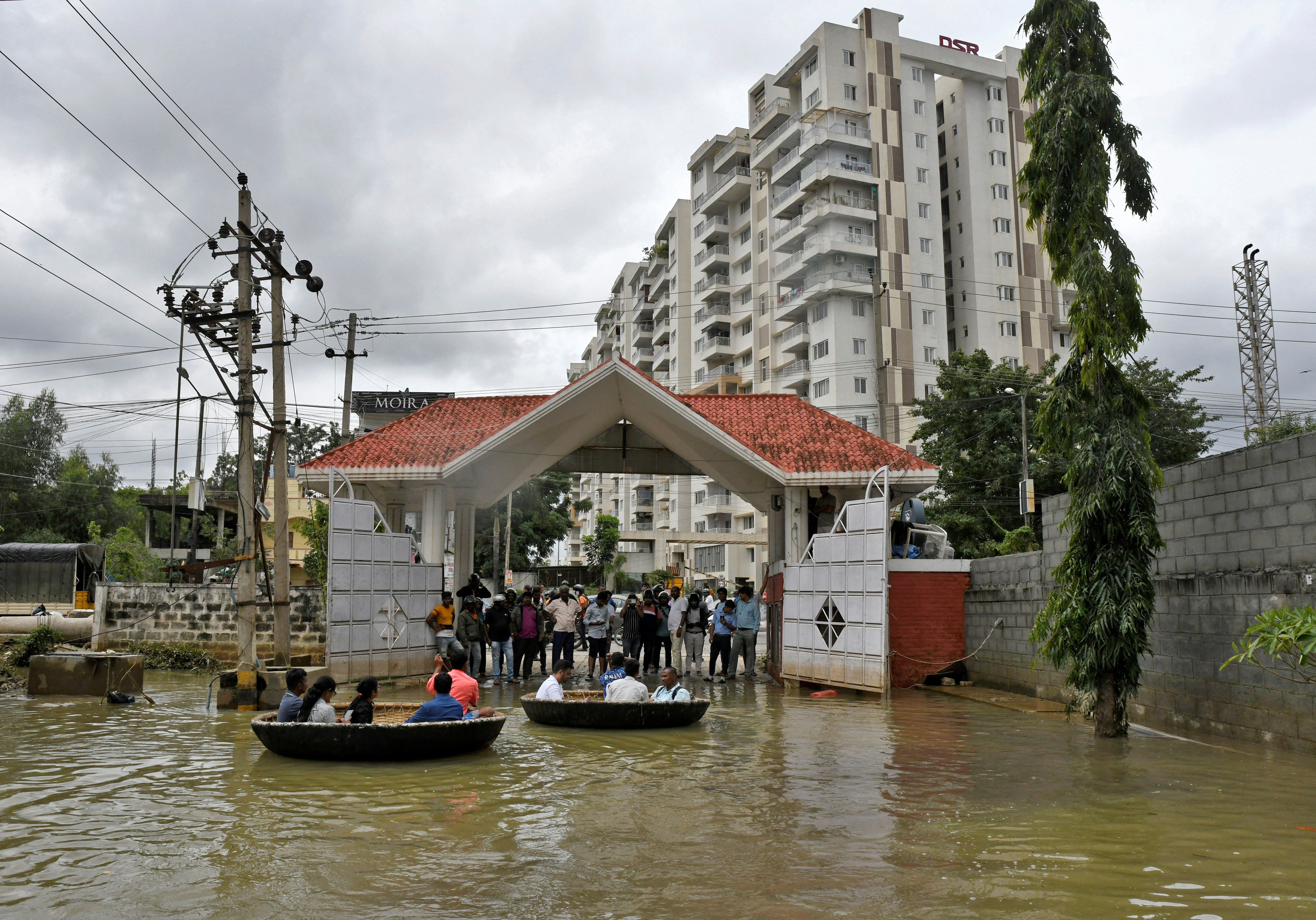 People use Coracle boats to move through a water-logged neighbourhood following torrential rains in Bengaluru