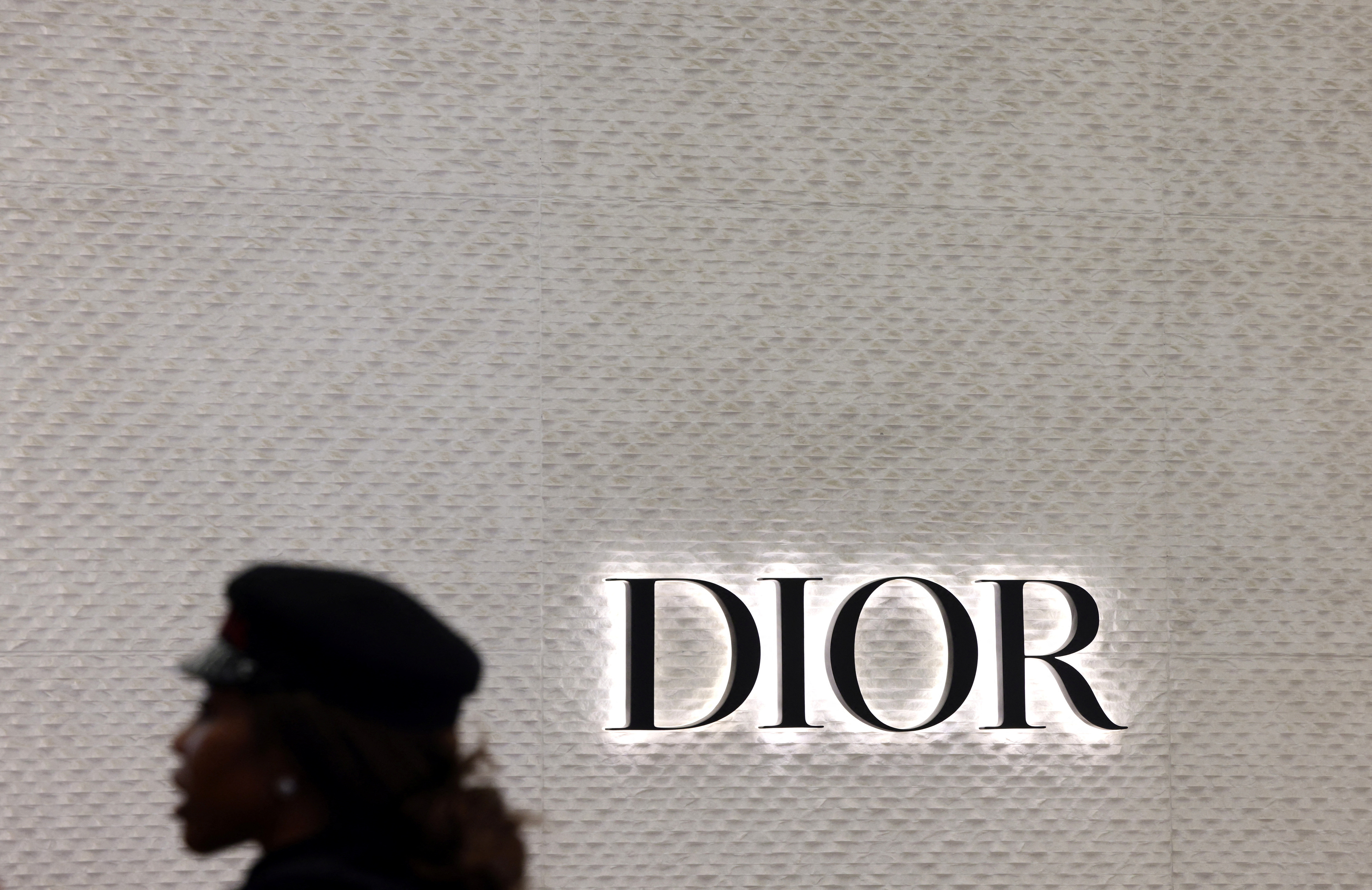 A woman walks in front of a Dior branded shop inside the department store 