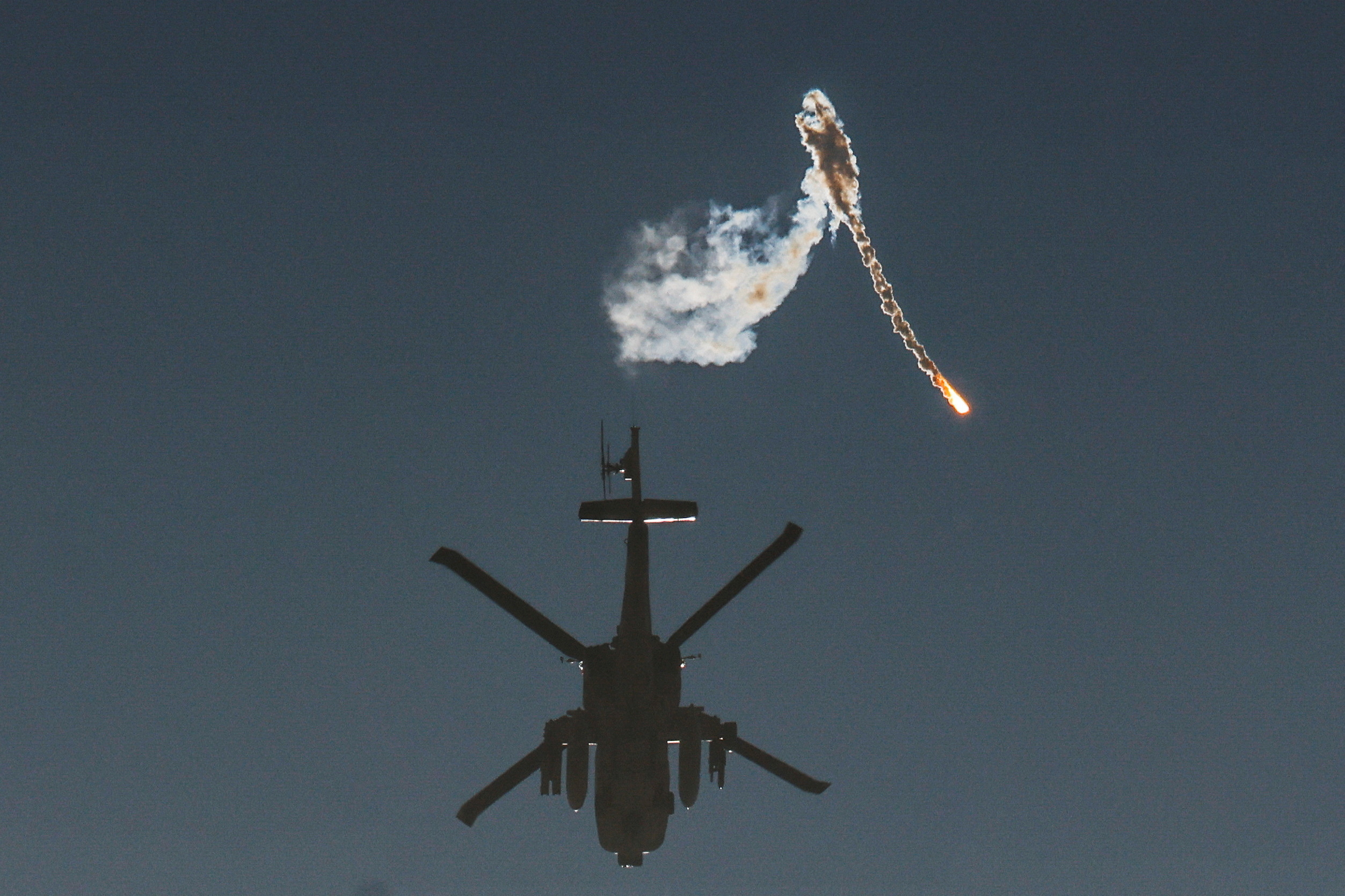 An Israeli military helicopter releases a flare over the Israel-Gaza border, after a temporary truce between Israel and the Palestinian Islamist group Hamas expired, as seen from southern Israel