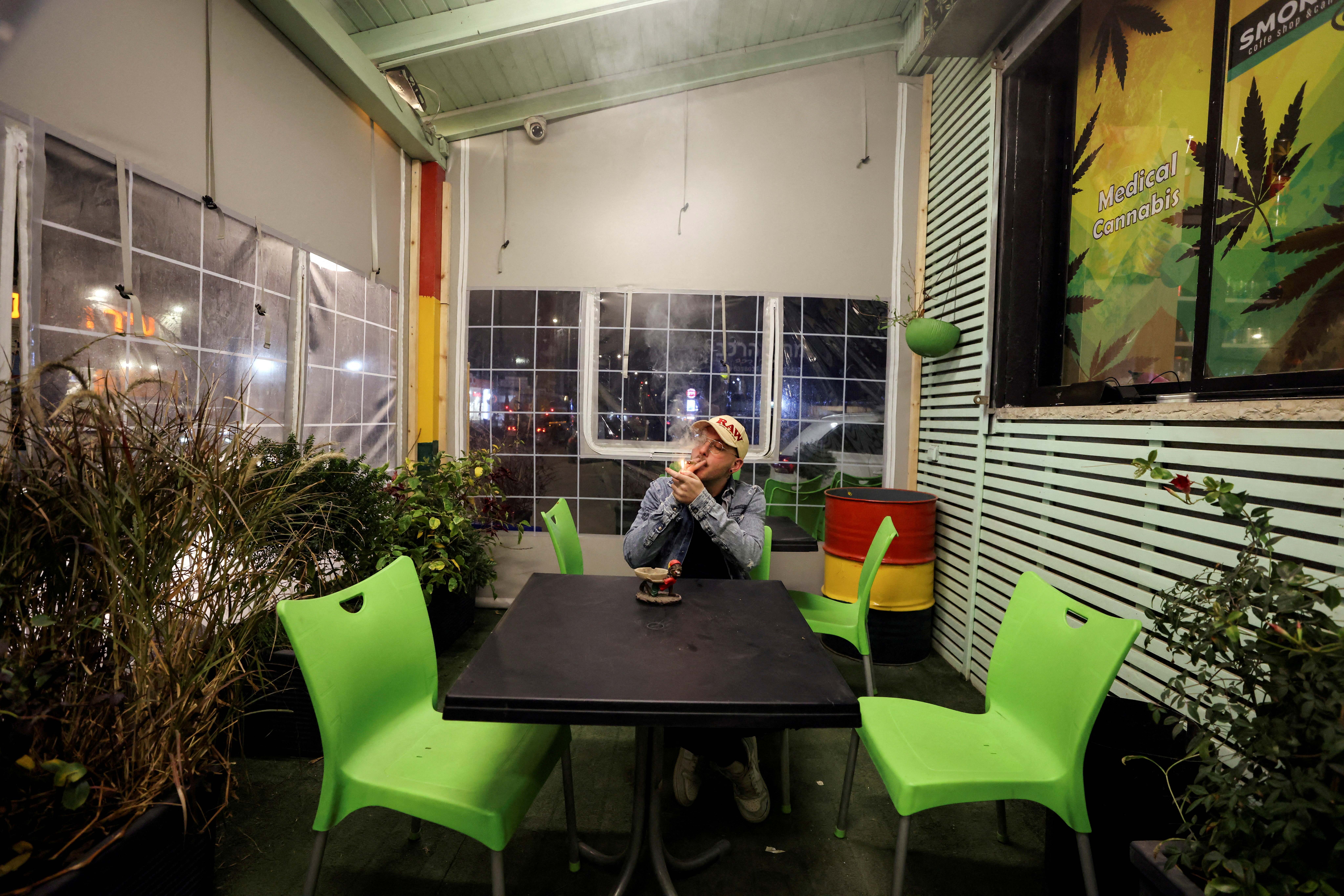 A worker smokes a joint at a medical cannabis cafe in Tira, an Arab village in central Israel