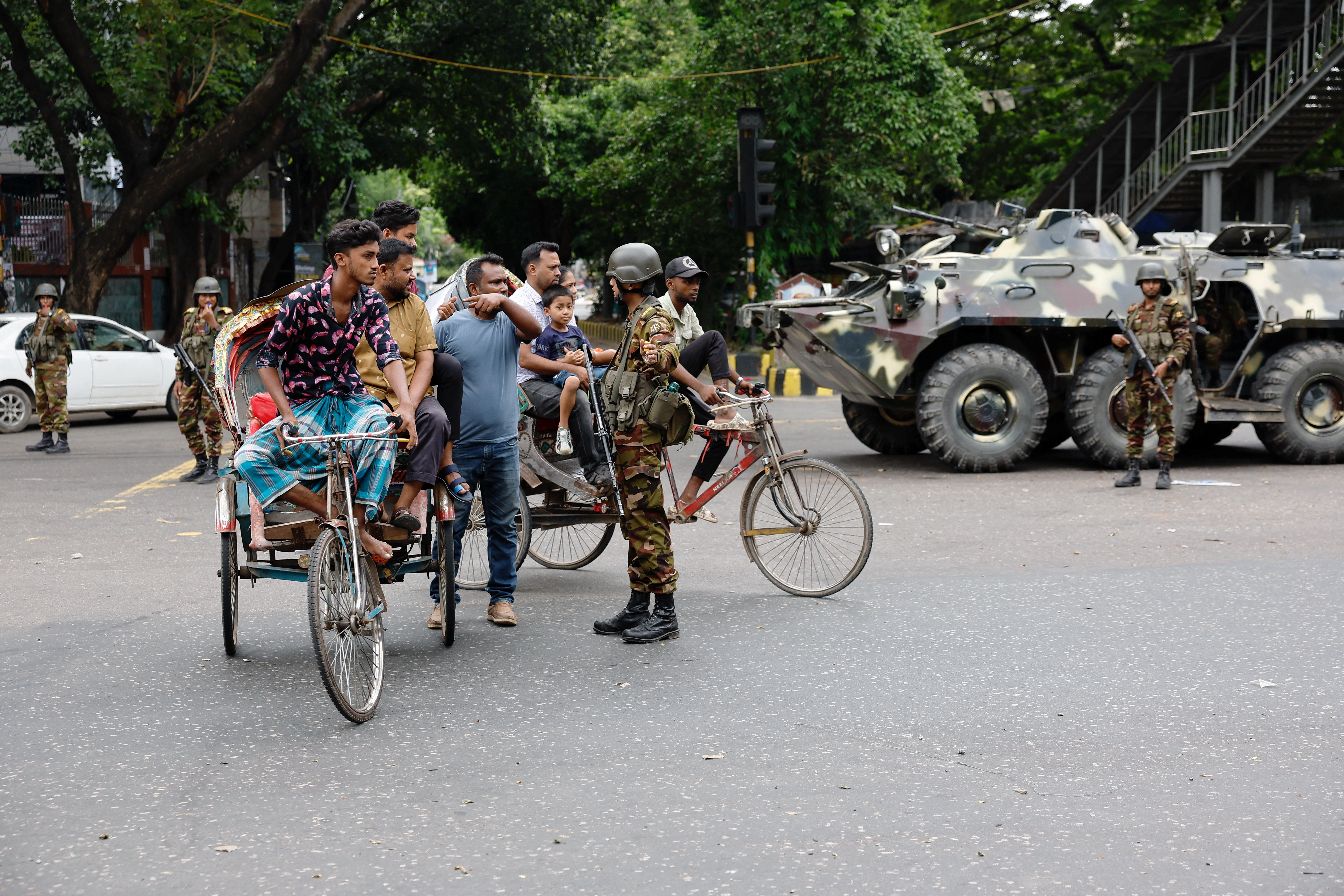 A member of the Bangladesh Army speaks with commuters on the second day of curfew, in Dhaka