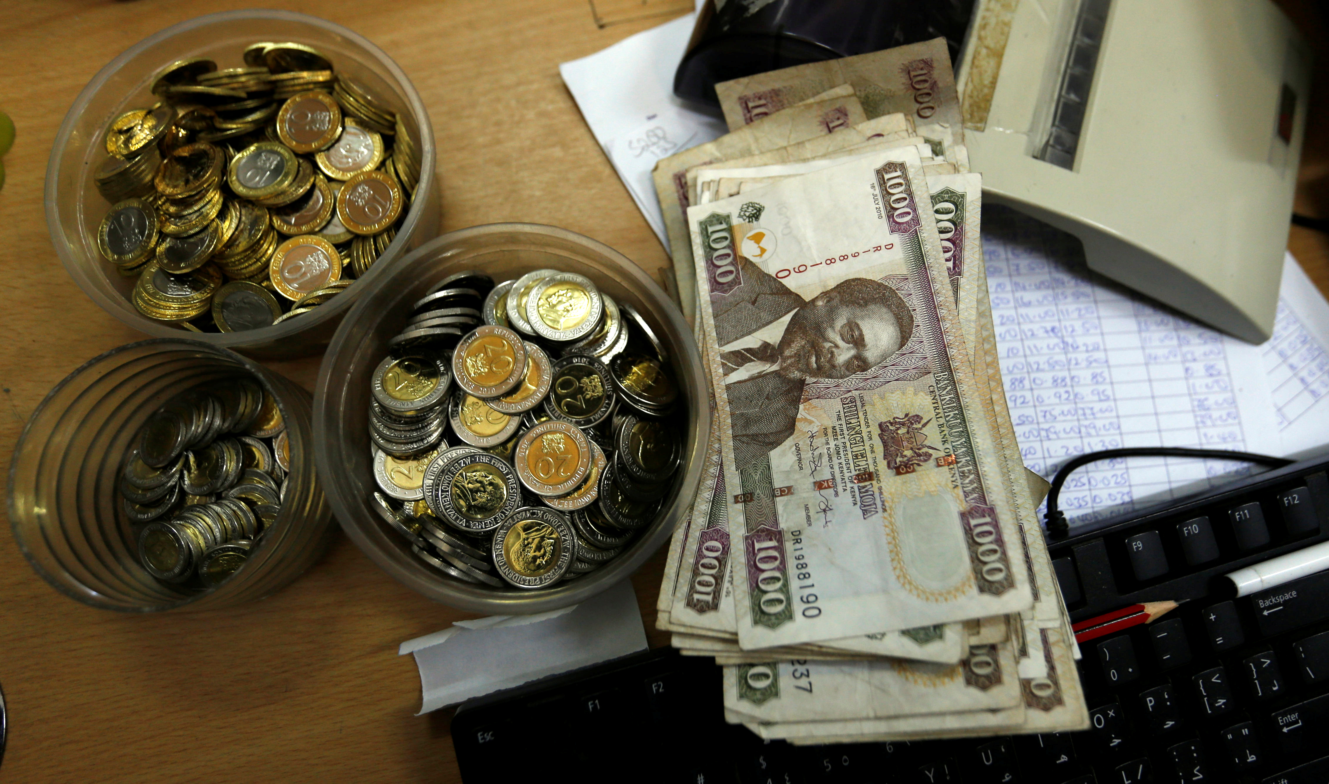 Kenya shilling coins and notes are pictured inside a cashier's booth at a forex exchange bureau in Kenya's capital Nairobi