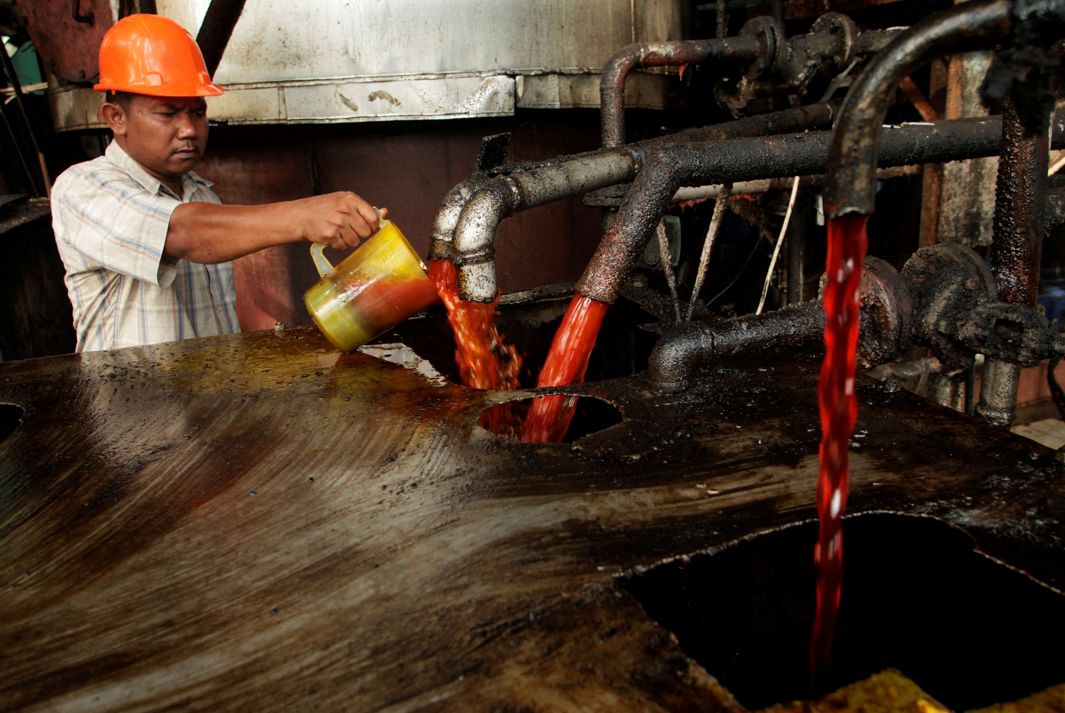 A worker checks the quality of crude palm oil (CPO) in a state CPO processing unit at Indonesia's North Sumatra province