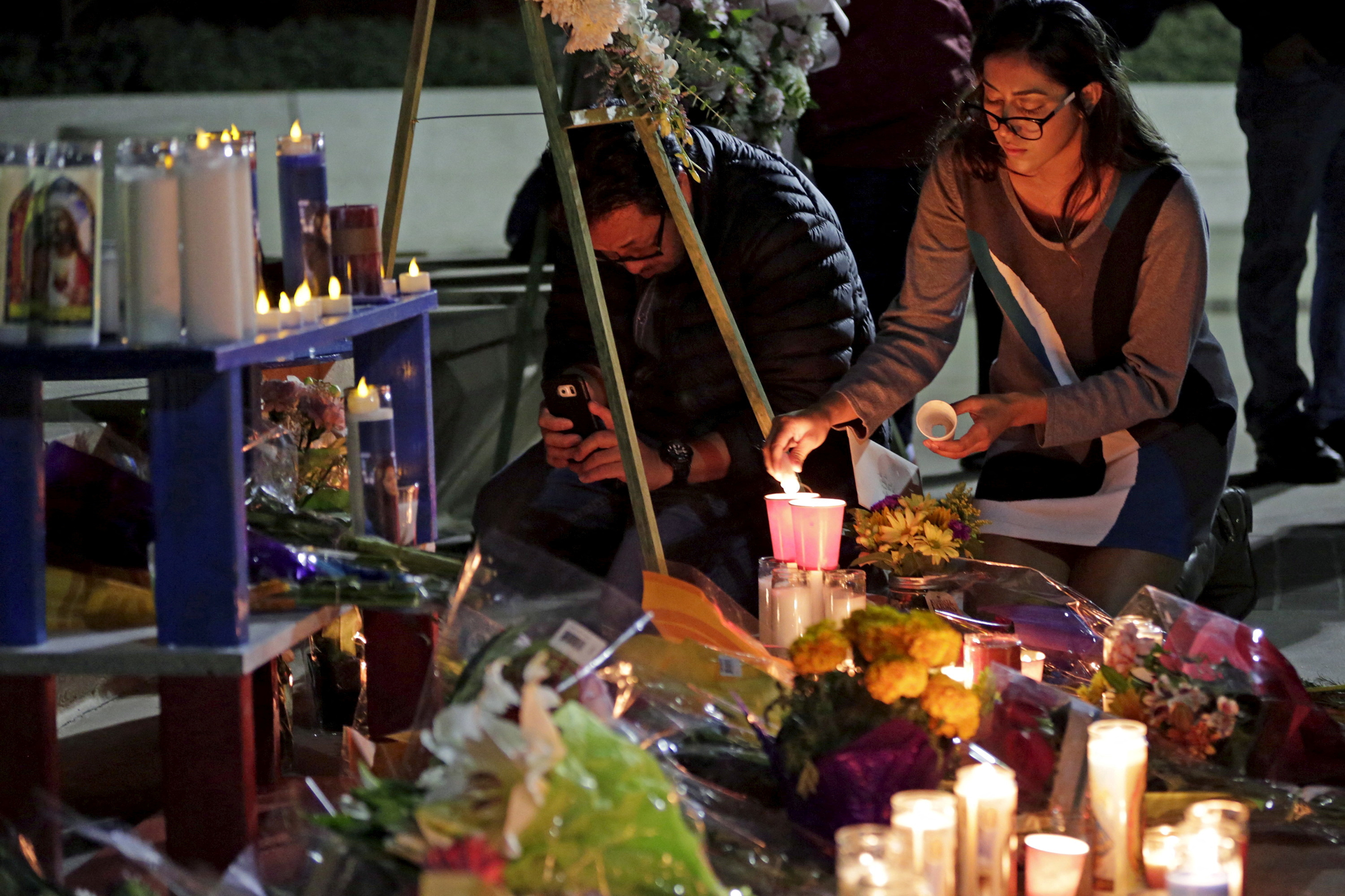 A woman places flowers at a makeshift shrine in honor of Nohemi Gonzalez at California State University in Long Beach, California