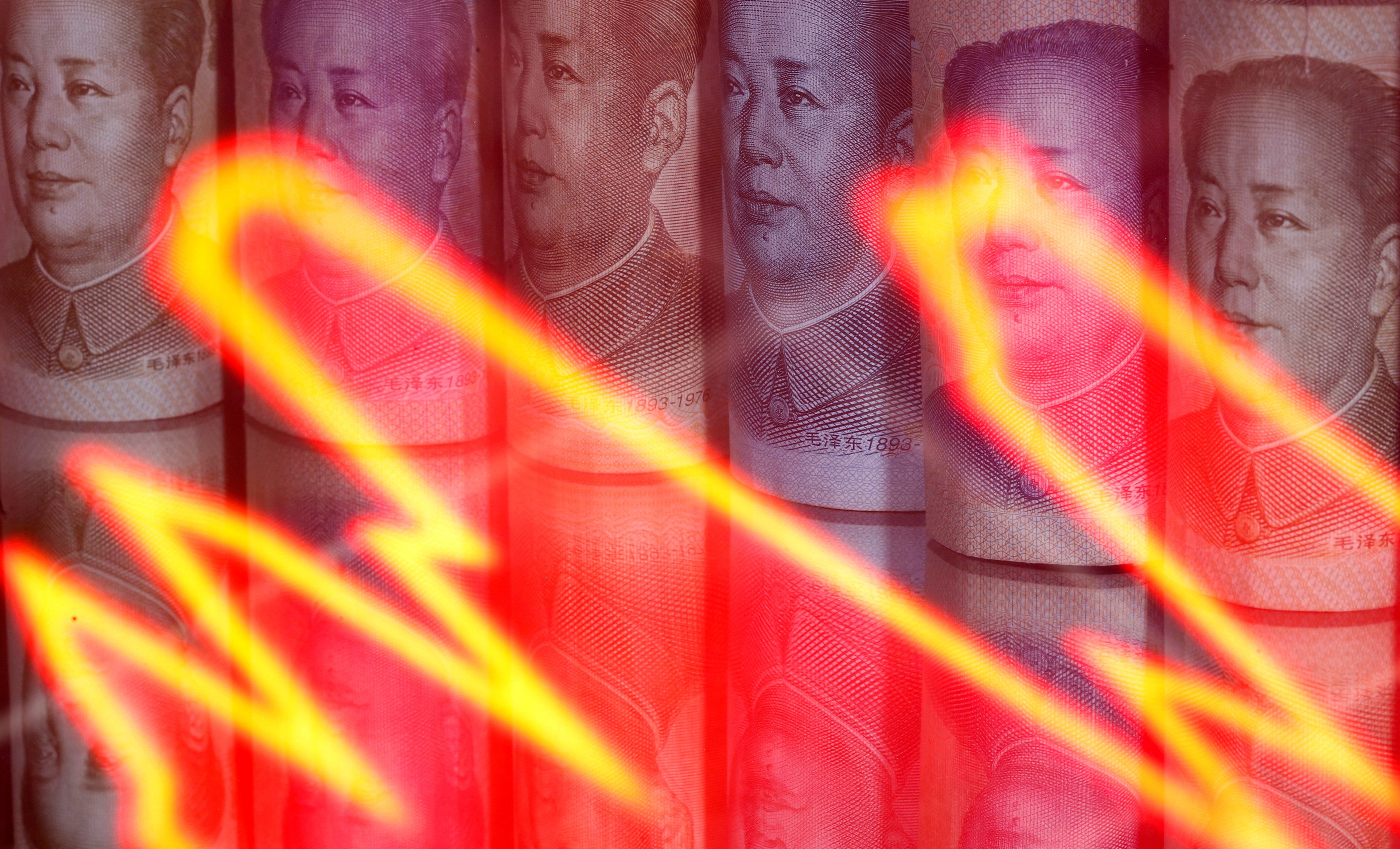 Chinese Yuan banknotes are seen behind illuminated stock graph in this illustration
