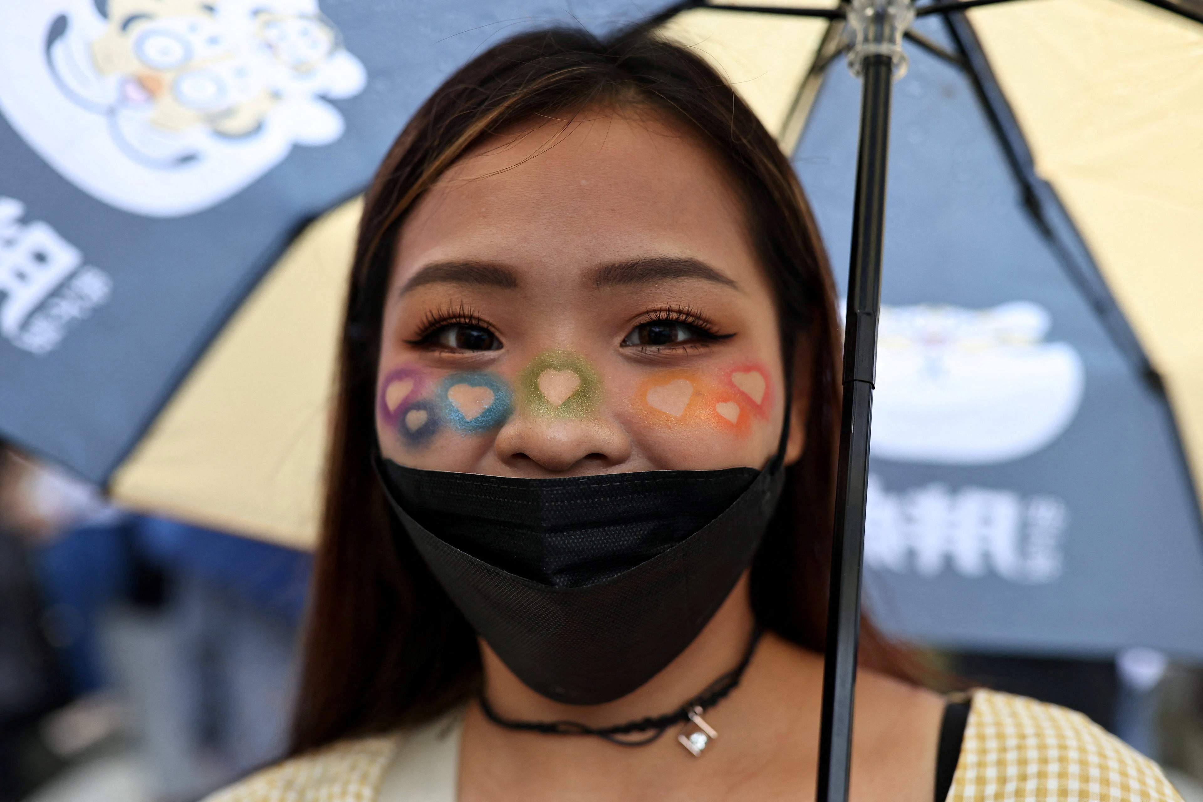 A girl with rainbow coloured face poses for a photo during the annual pride parade in Taipei