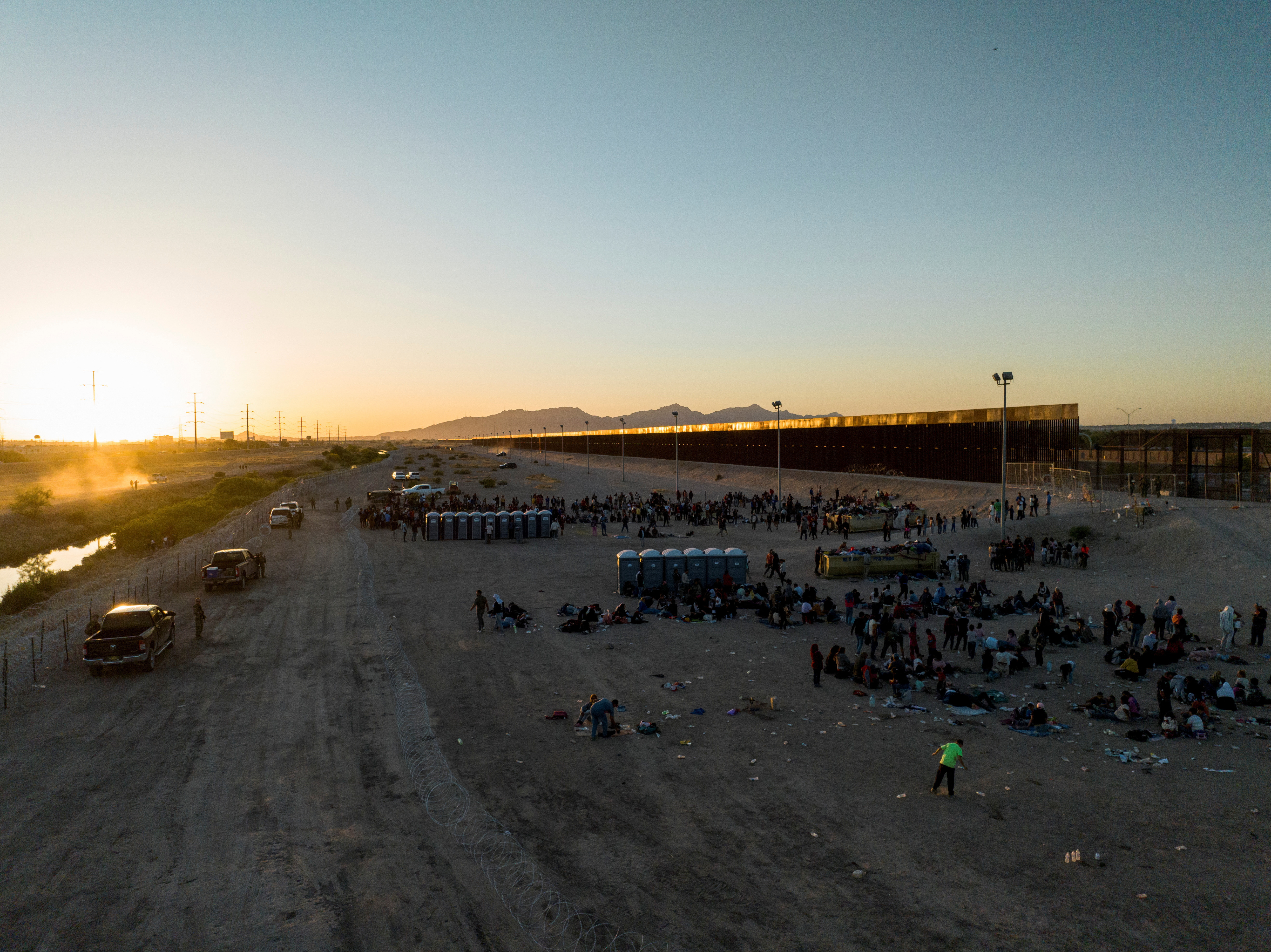 Migrants stand along the border highway in El Paso, Texas