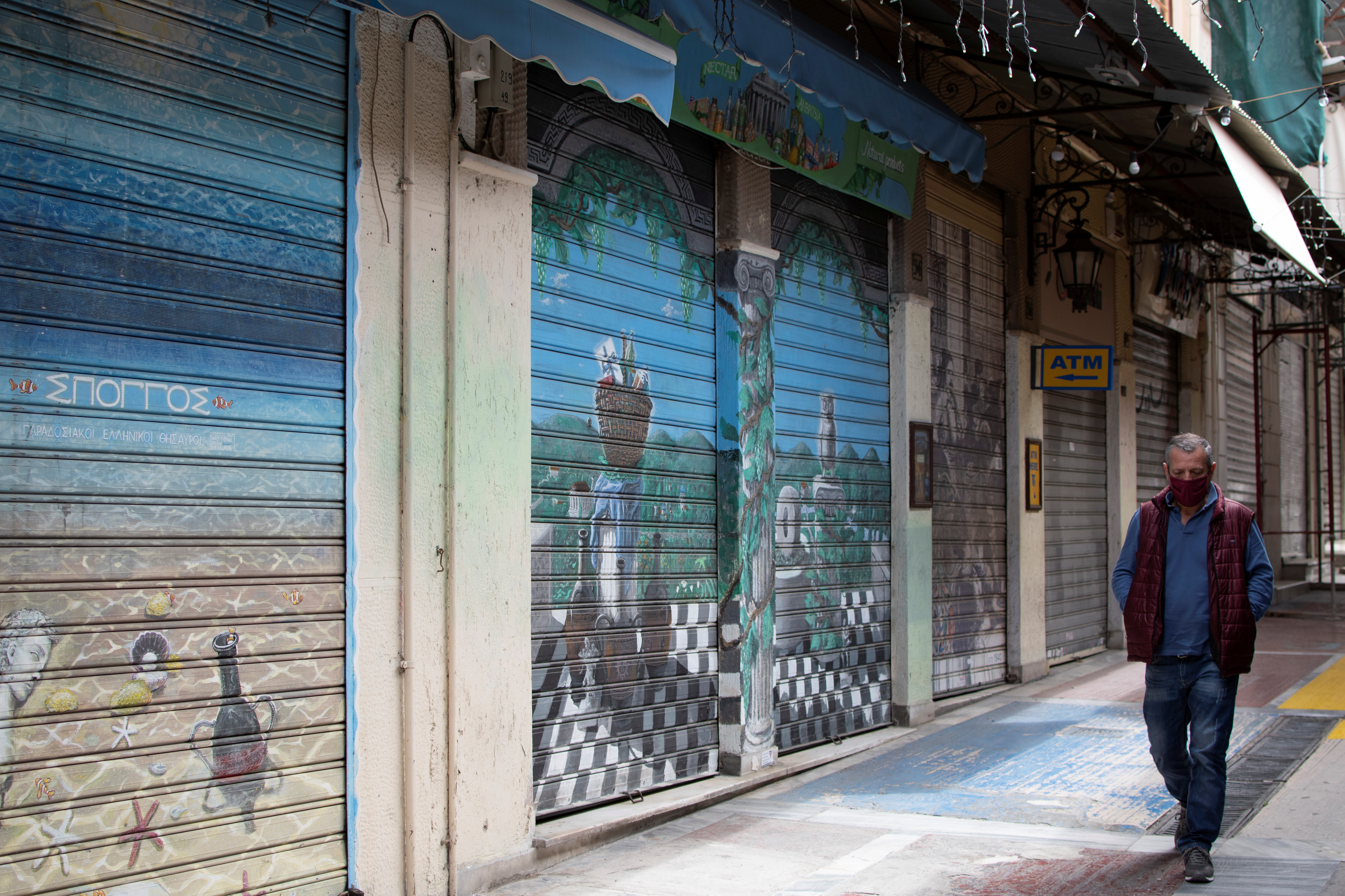 A man wearing a protective face mask walks past closed shops in the Monastiraki area, amid the coronavirus disease (COVID-19) pandemic in Athens, Greece April 4, 2021. REUTERS/Konstantinos Tountas/File Photo