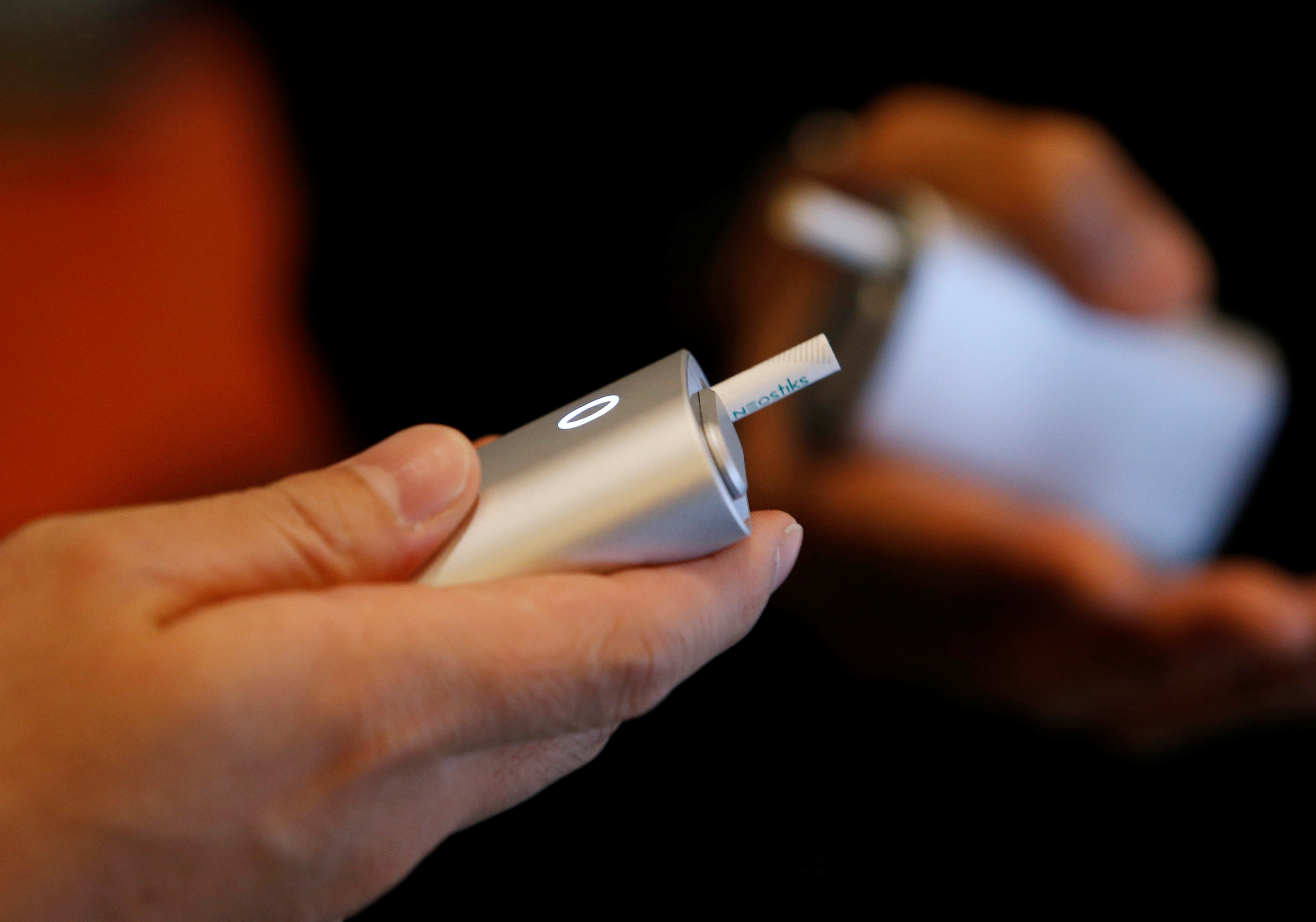Attendees try British American Tobacco's new tobacco heating system device 'glo' after a news conference in Tokyo, Japan