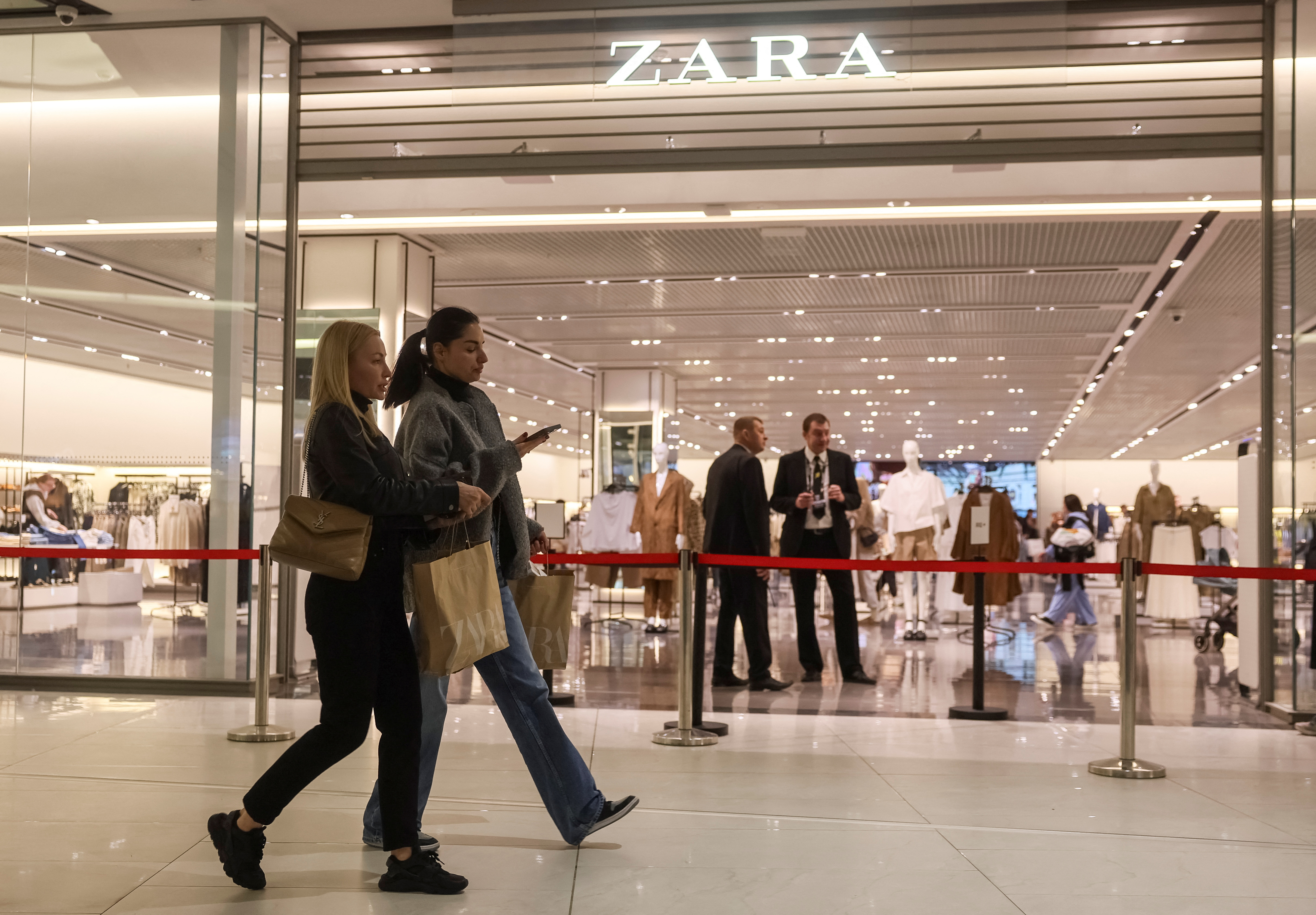 Shoppers walk near a Zara store in a shopping mall in Kyiv